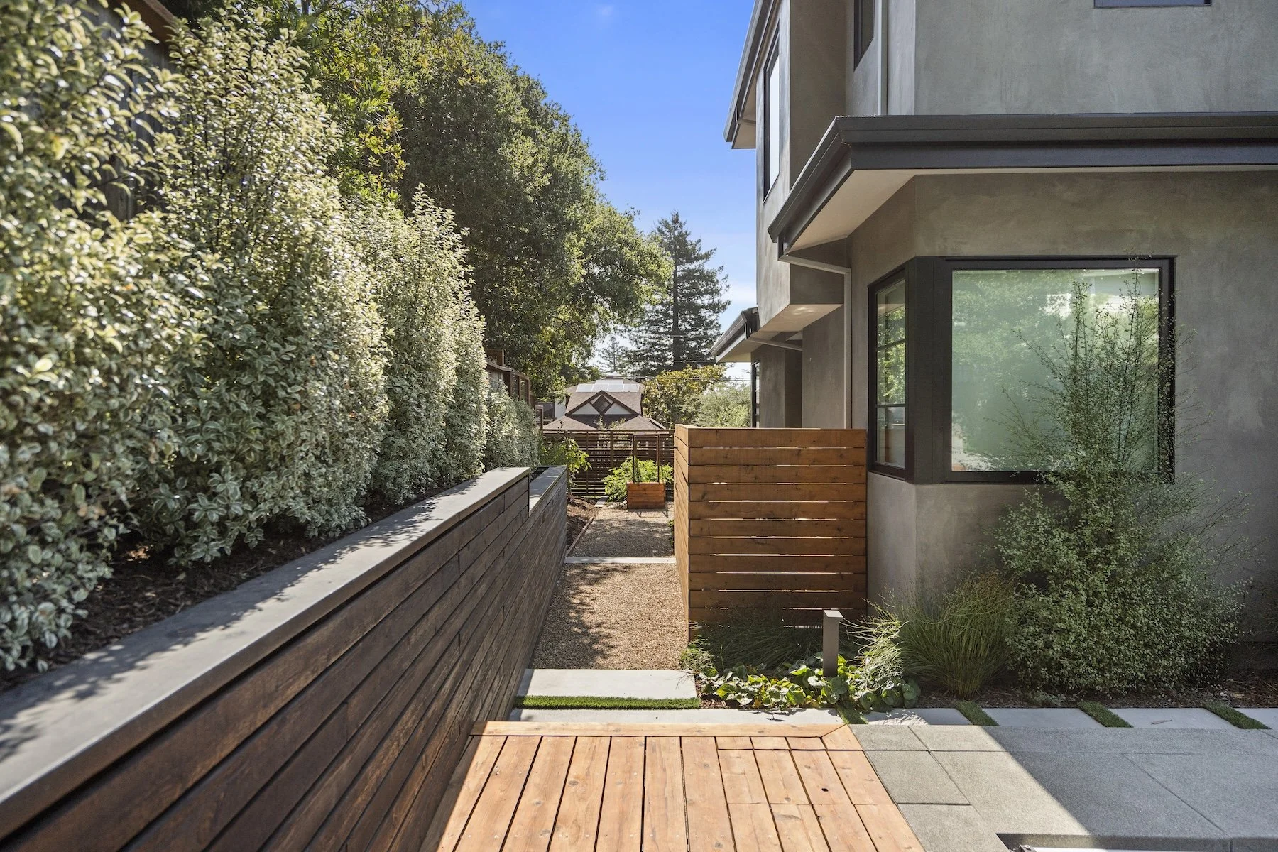 Wood decking and retaining walls leading to backyard of modern home