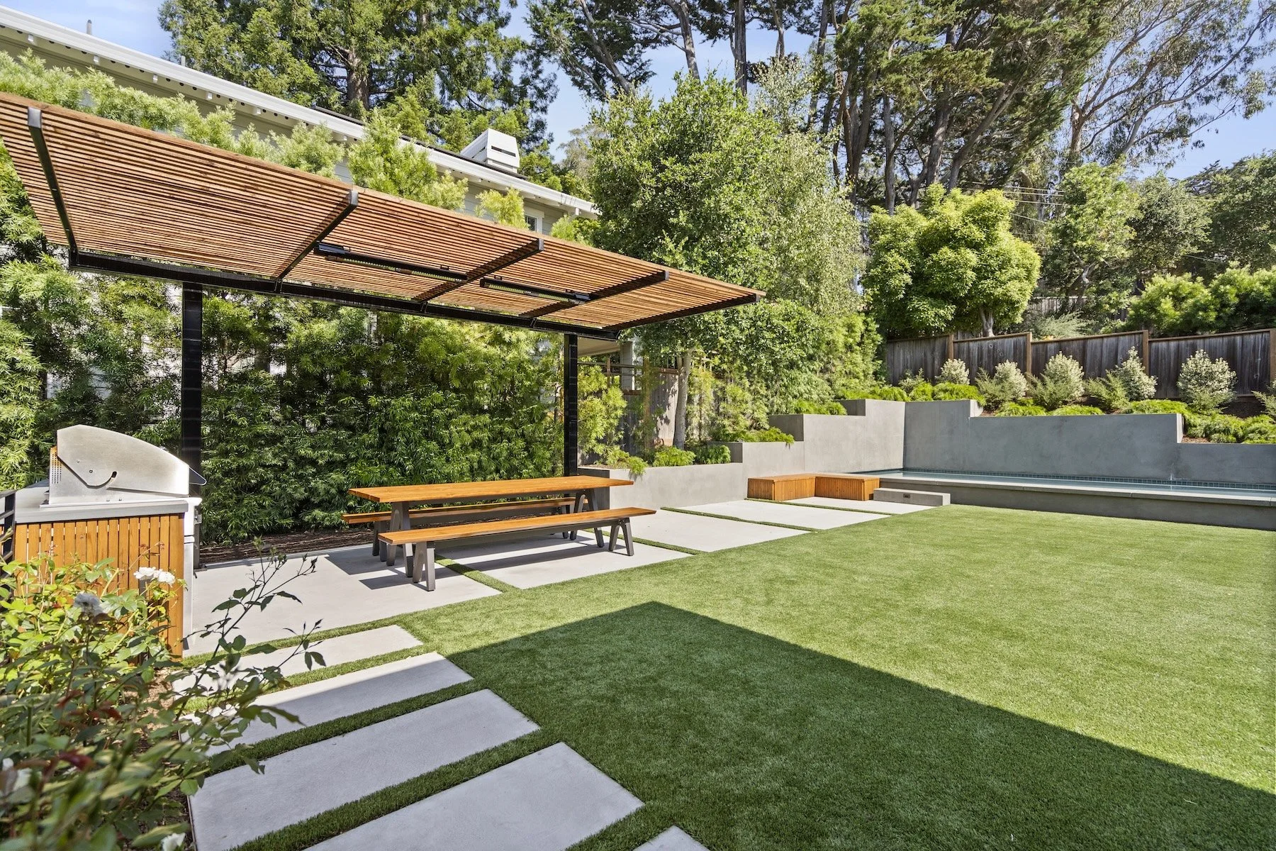 Outdoor kitchen and inground pool by Heritage Landscapes