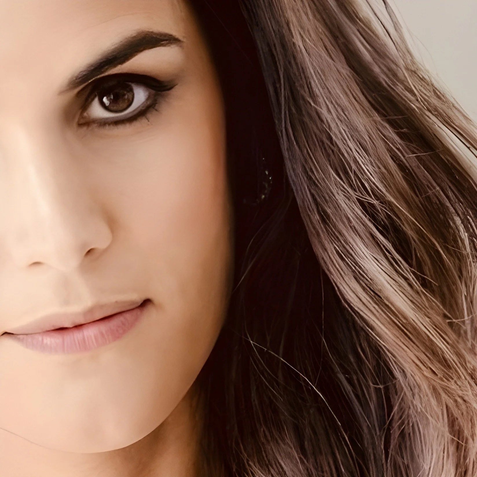 Une femme souriante avec des lunettes porte un t-shirt et un jean, une femme plus âgée avec des lunettes et une chemise à manches courtes tirant sur un jean, tenant une écharpe qui relie les deux.