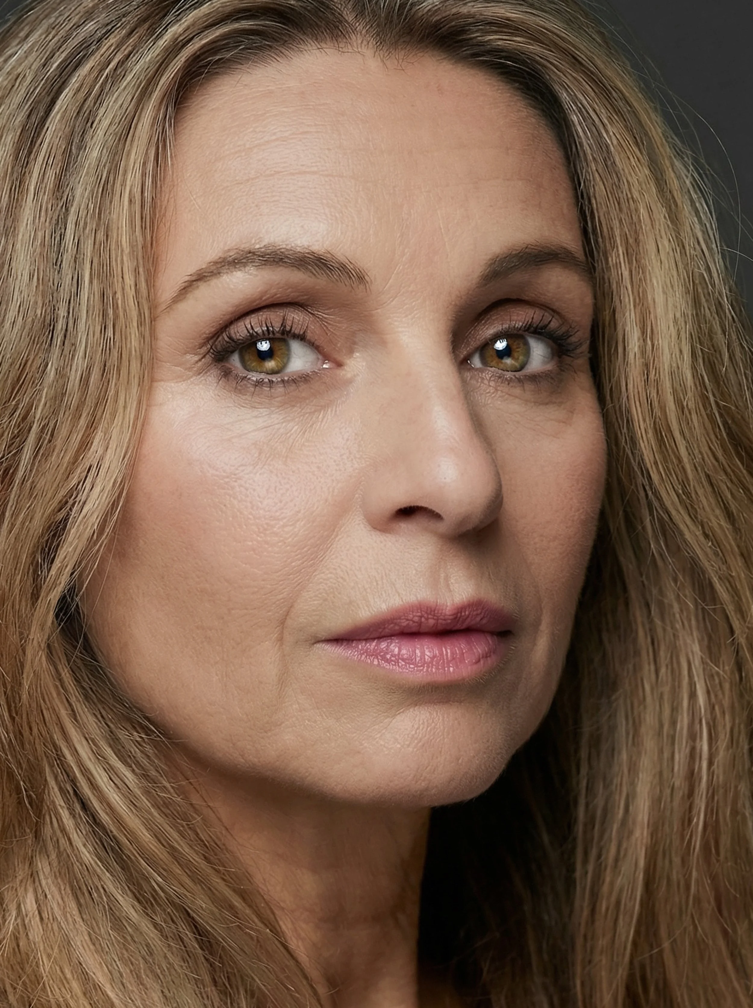 Portrait d'une jeune femme aux cheveux roux avec un fond flou de nature verte.