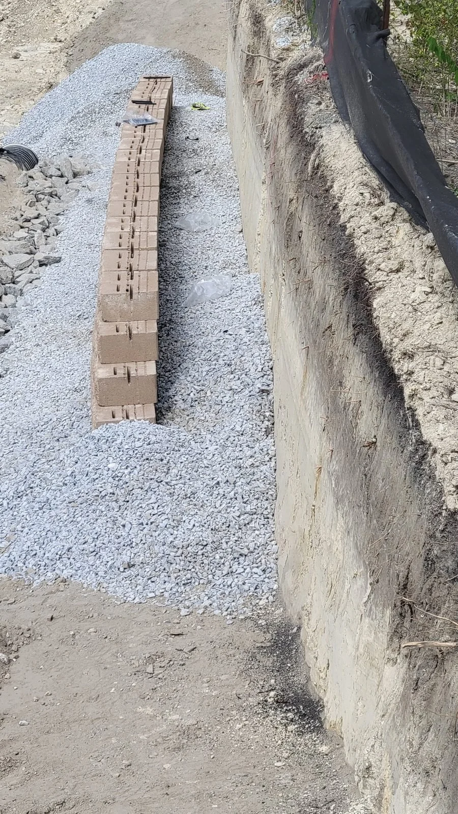 Site Work: Permeable Paver Lot & Retaining Wall — block retaining wall courses going up, Hughes 360 Services