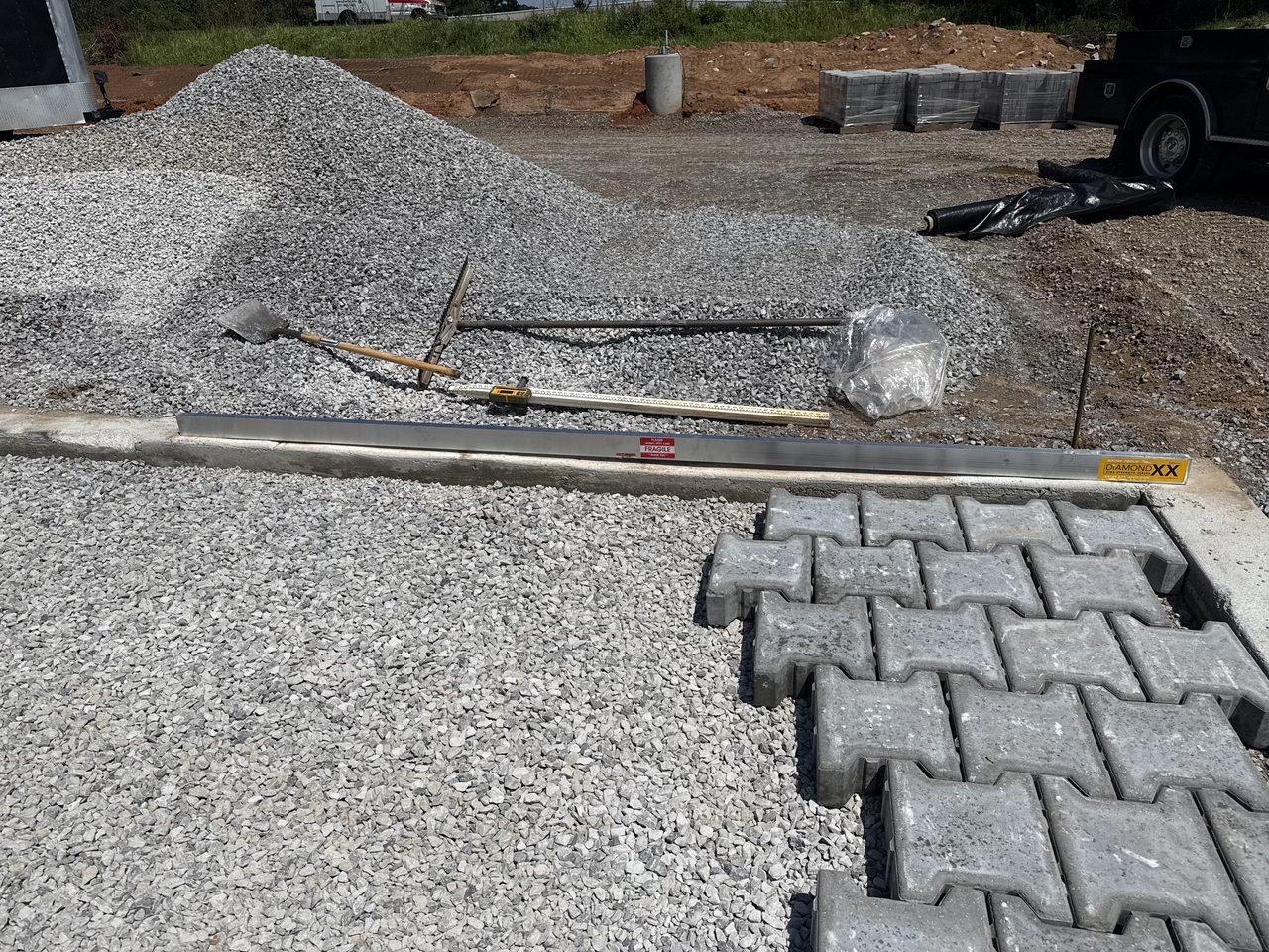 Site Work: Permeable Paver Lot & Retaining Wall — permeable paver course running along the curb, Hughes 360 Services