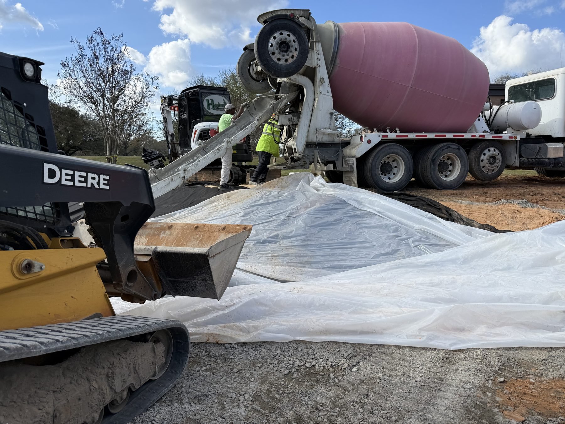US Coast Guard Drainage Channel Repair — mixer pouring concrete over poly, Hughes 360 Services