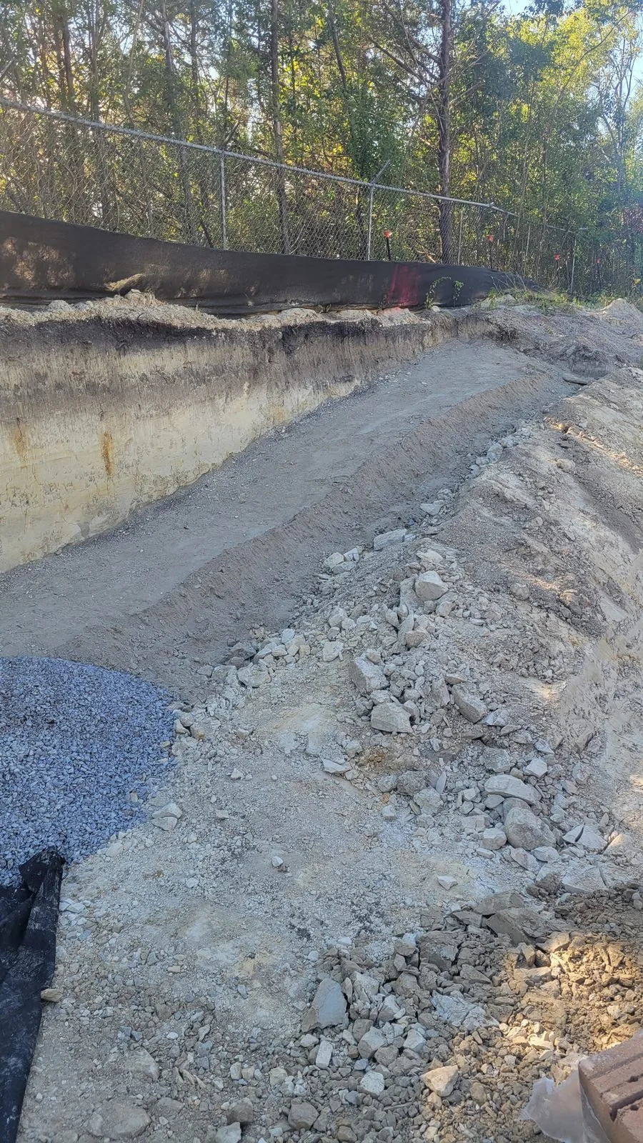 Site Work: Permeable Paver Lot & Retaining Wall — grade before the retaining wall was built, Hughes 360 Services
