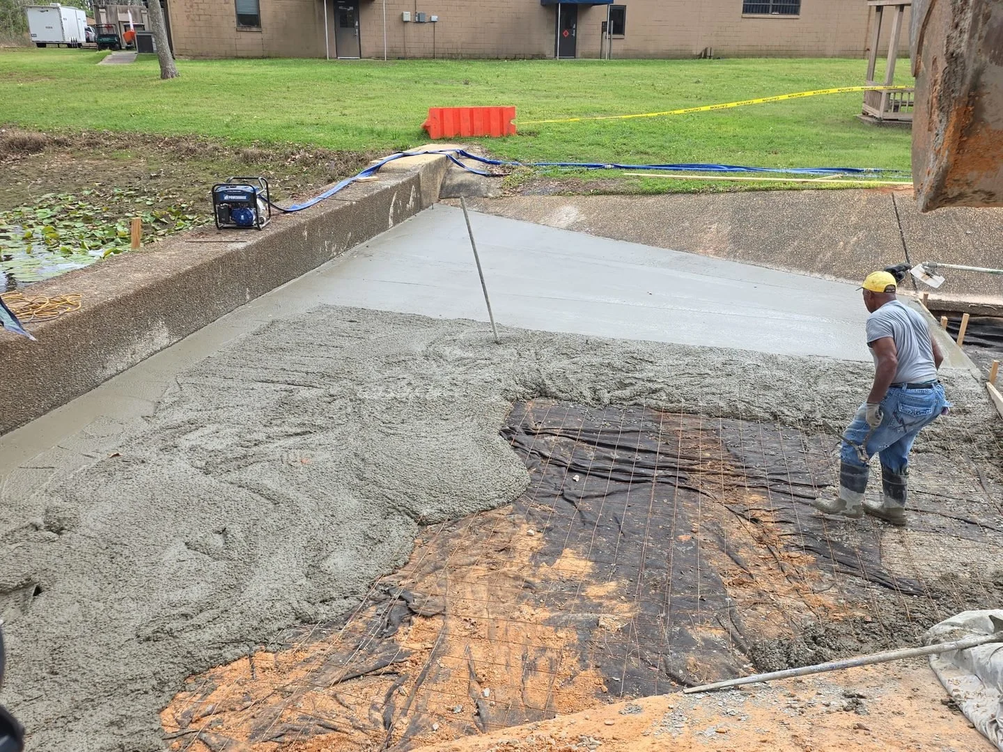 US Coast Guard Drainage Channel Repair — concrete pour next to the brick building, Hughes 360 Services