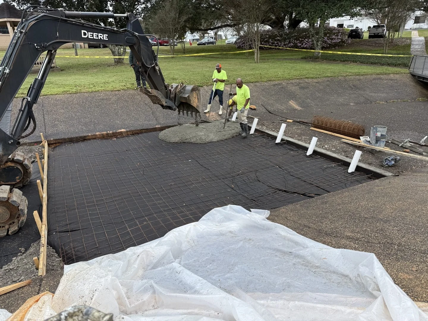 US Coast Guard Drainage Channel Repair — excavator placing concrete in the channel, Hughes 360 Services