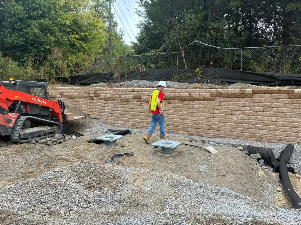 Site Work: Permeable Paver Lot & Retaining Wall — finished wall with drain pipe and area inlet, Hughes 360 Services