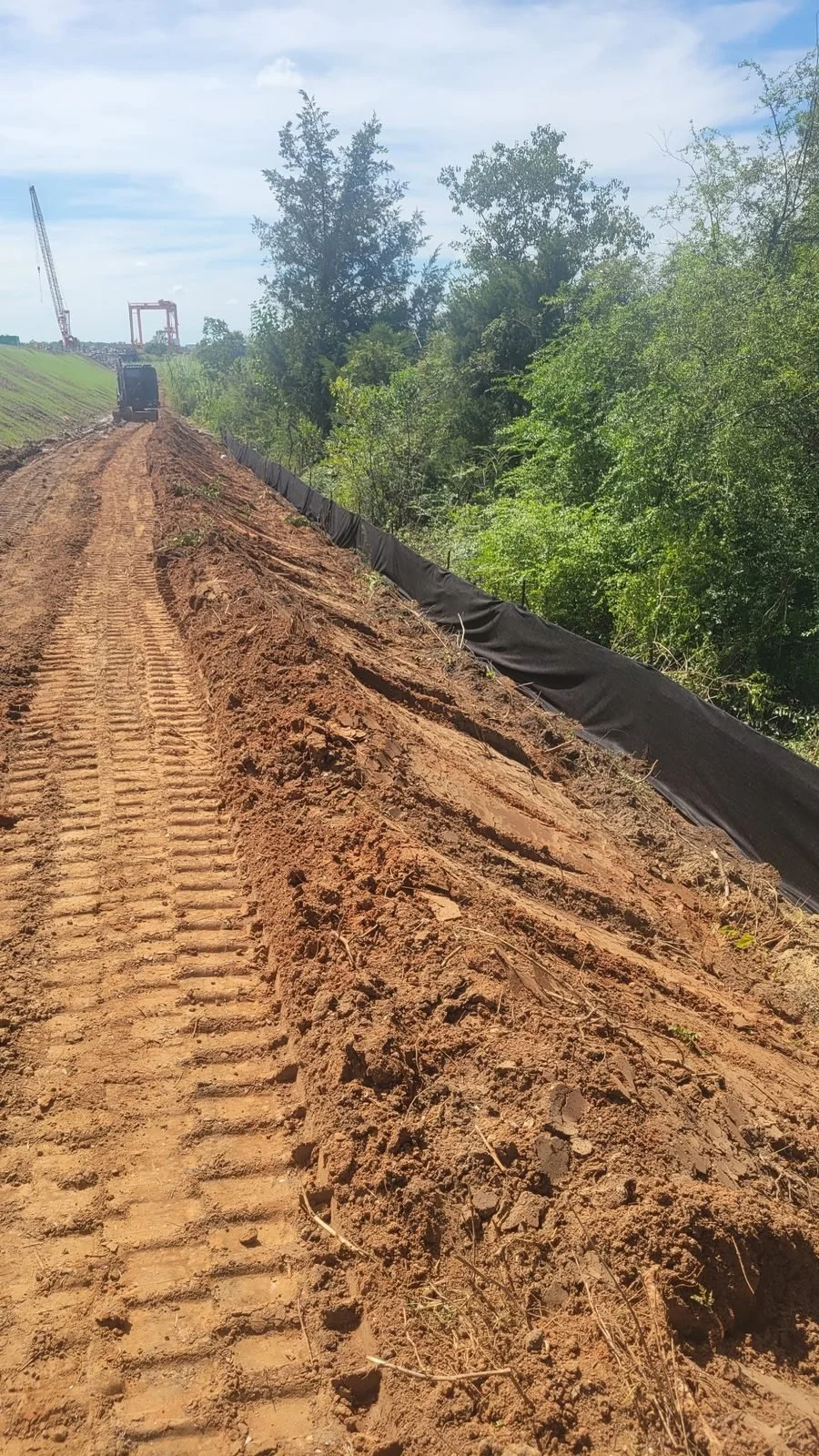 Erosion and sediment control, Mobile AL — excavator cutting the creek bank, Hughes 360 Services