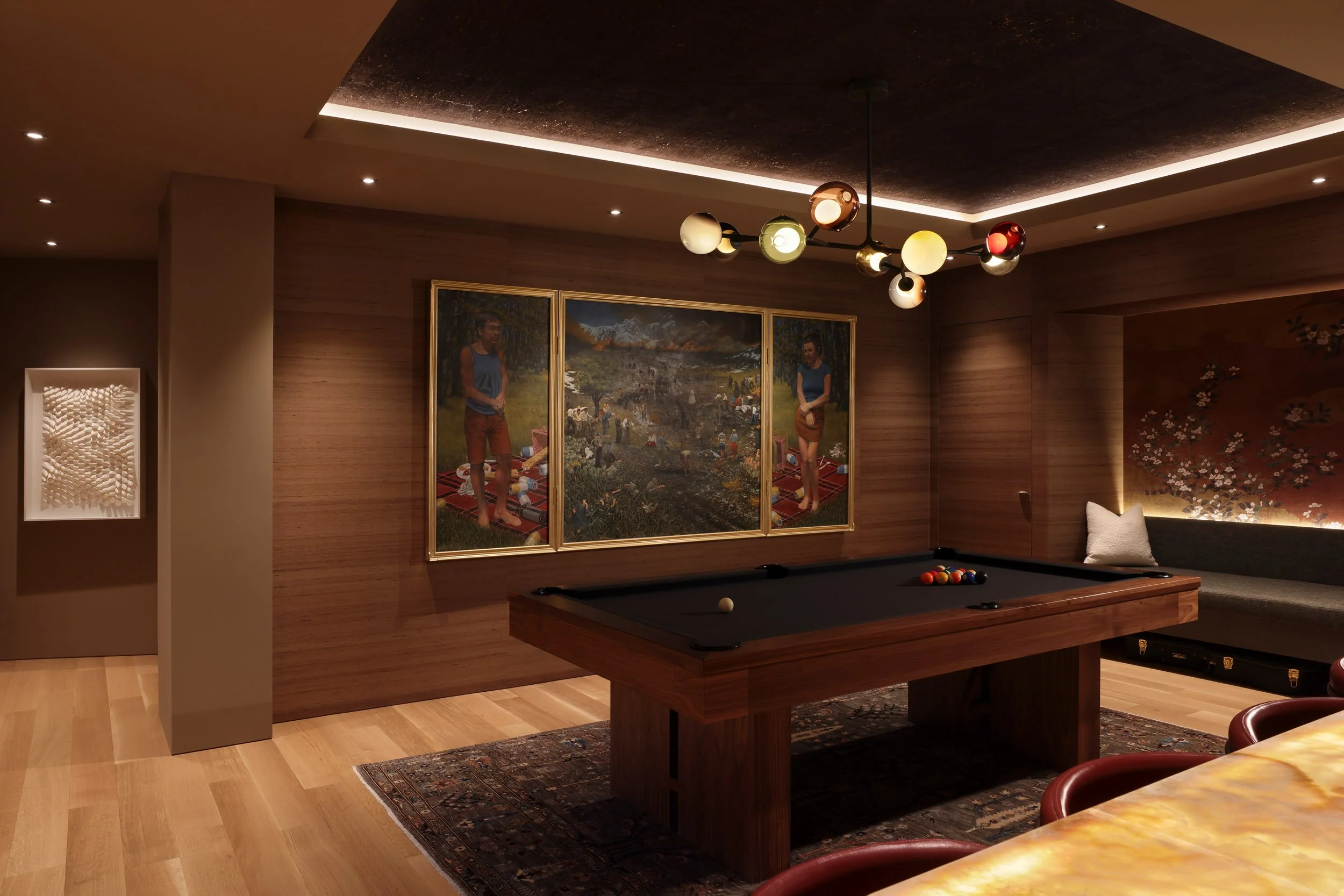 A game room with a pool table, a modern chandelier, framed artwork on the wall, and a bench with a pillow.