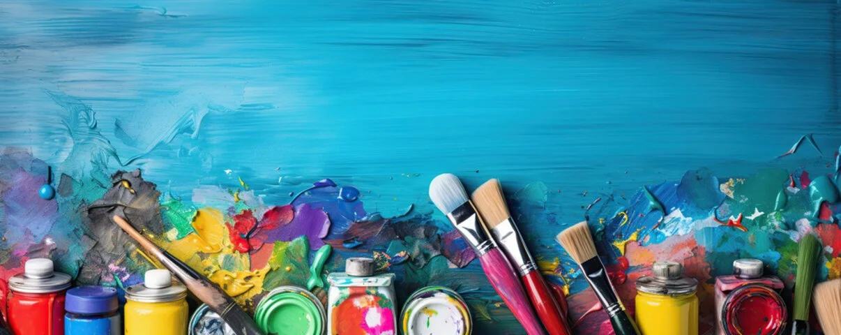 Colorful paint tubes and brushes on an artistic palette representing Art Therapy