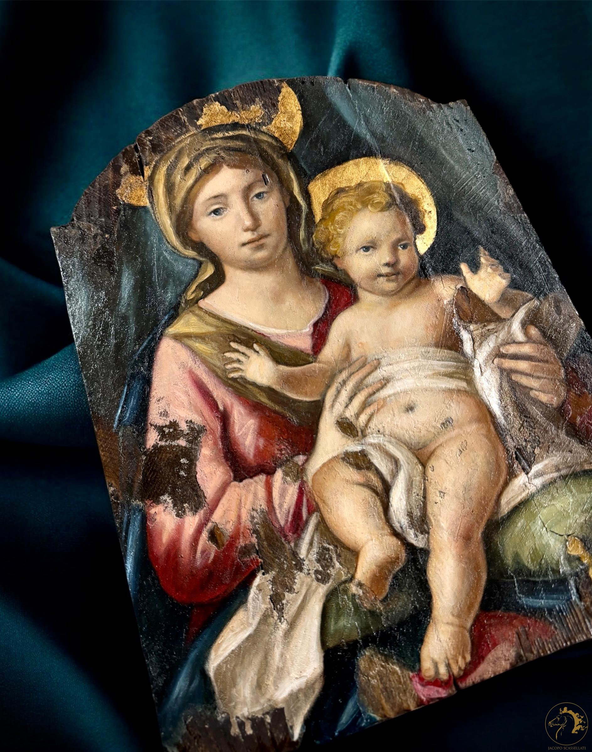 A damaged, vintage religious painting of Madonna and Child with halos, showing signs of peeling and wear.