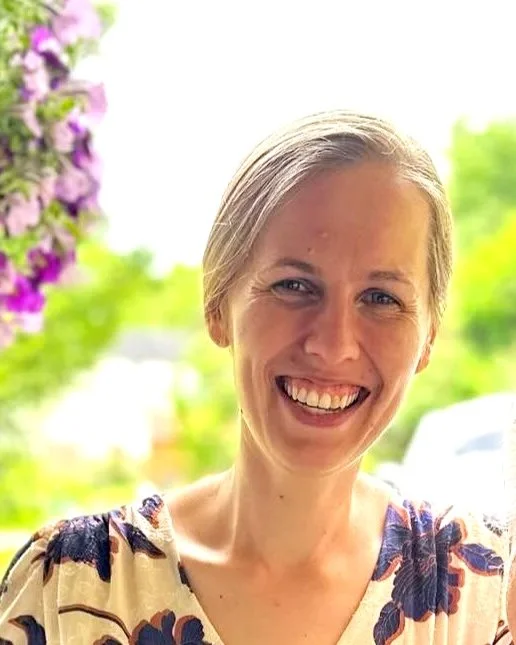 Woman smiling in front of stone wall