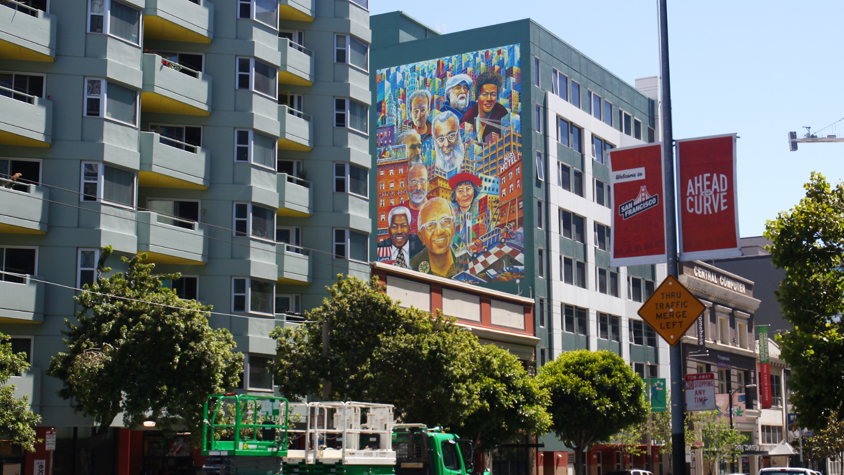This image is over Michael Rios' public art piece titled 'People First'. The mural is on Coleman House and next to Woolf House, both are TODCO Group affordable housing residences located in San Francisco's South of Market neighborhood.