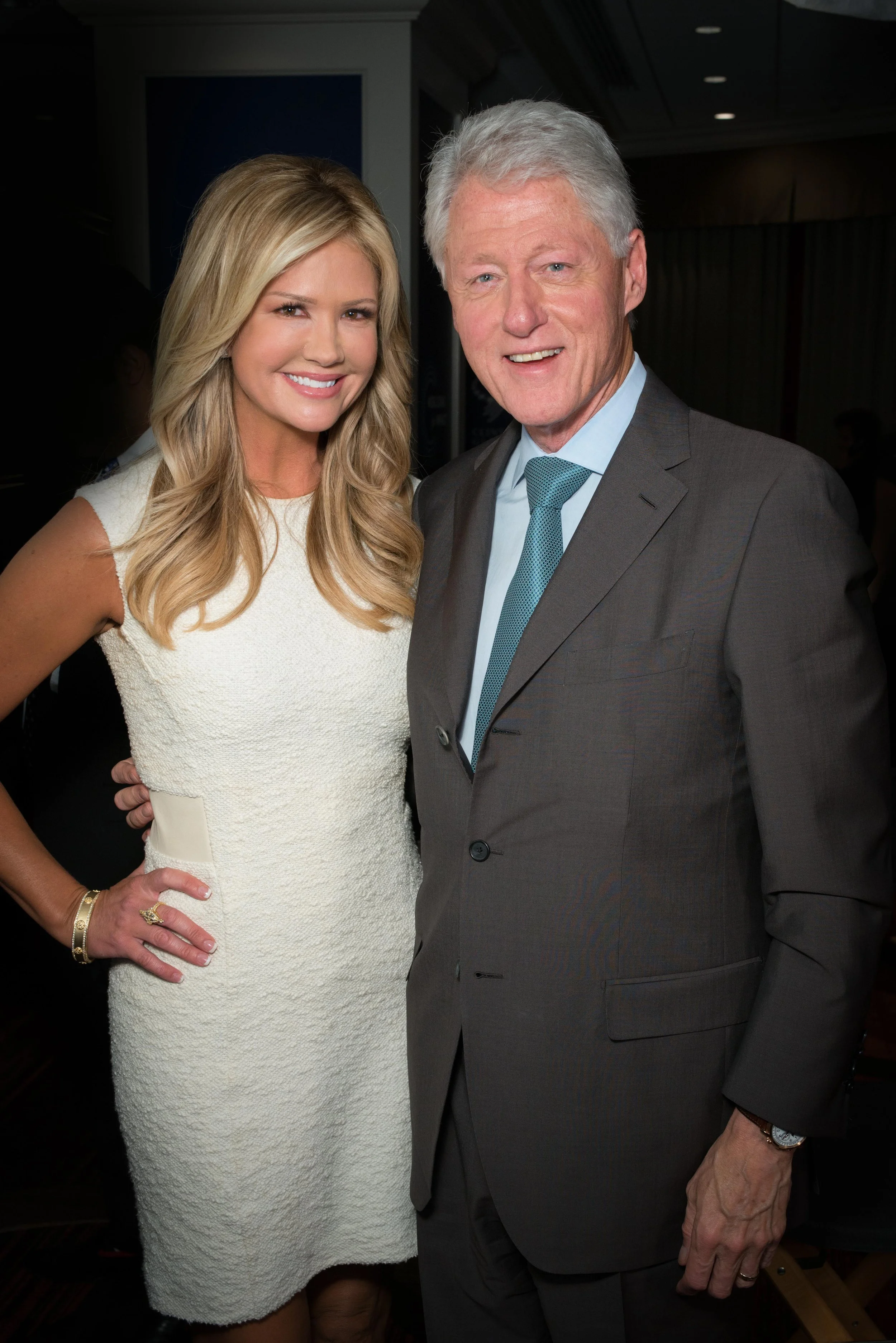 A man and woman dressed in formal attire posing together at an event.