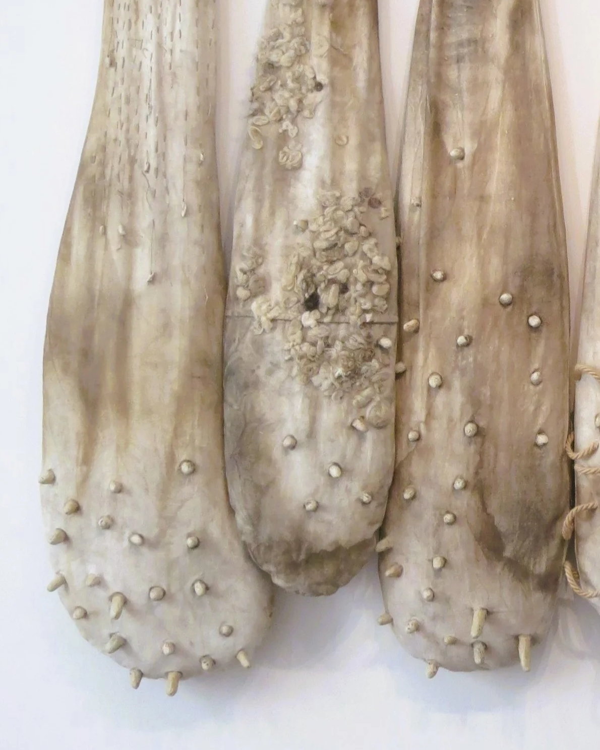 Gants en cuir beige décorés de clous et de fleurs en relief.