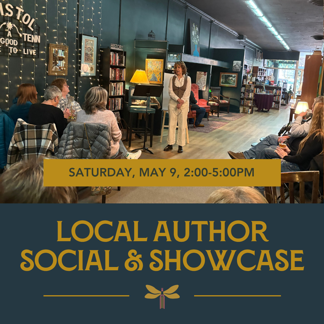 A view of a large room with a white woman wearing a cream shirt and pants and a brown vest talking in front of an audience.