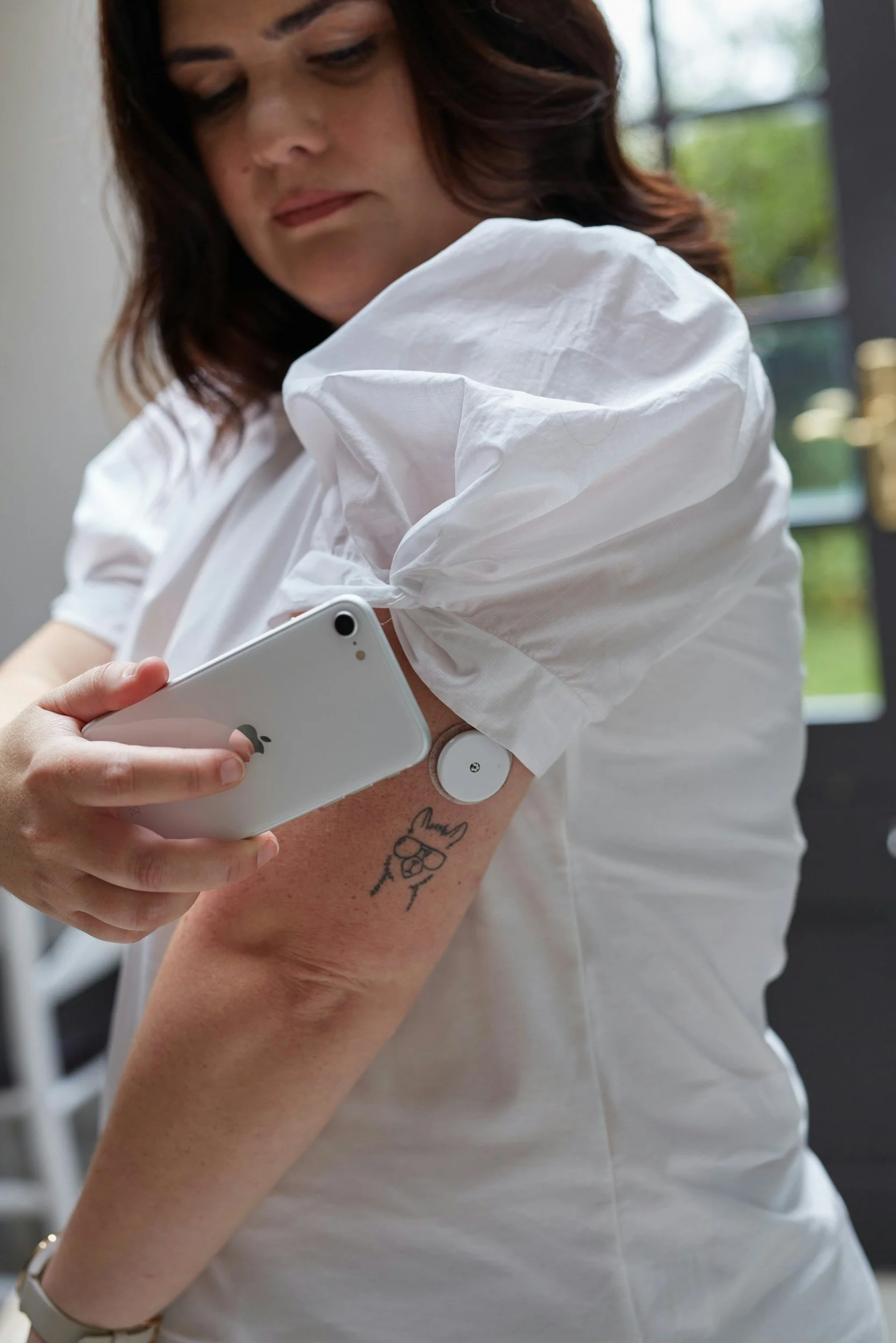 Woman wearing a continuous glucose monitor on her arm