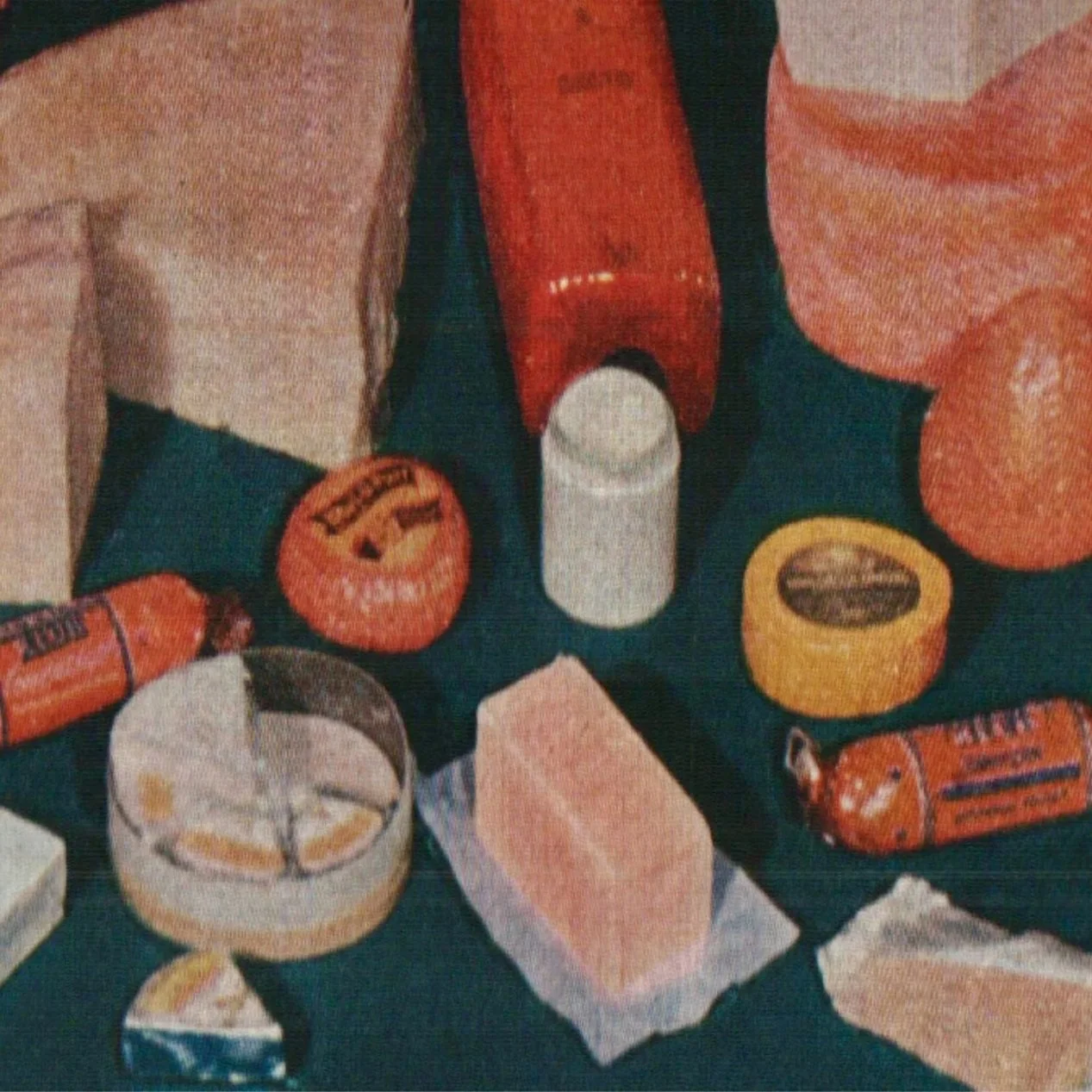 Assorted cheese varieties displayed on a dark surface, including wedges, rounds, and packaged slices.