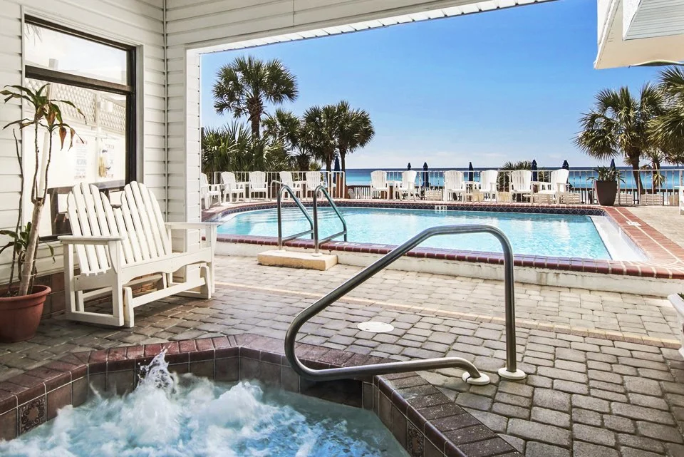 Image of the Osprey on the Gulf's hot tub and pool with pool chairs, chase lounges and a view of the ocean.