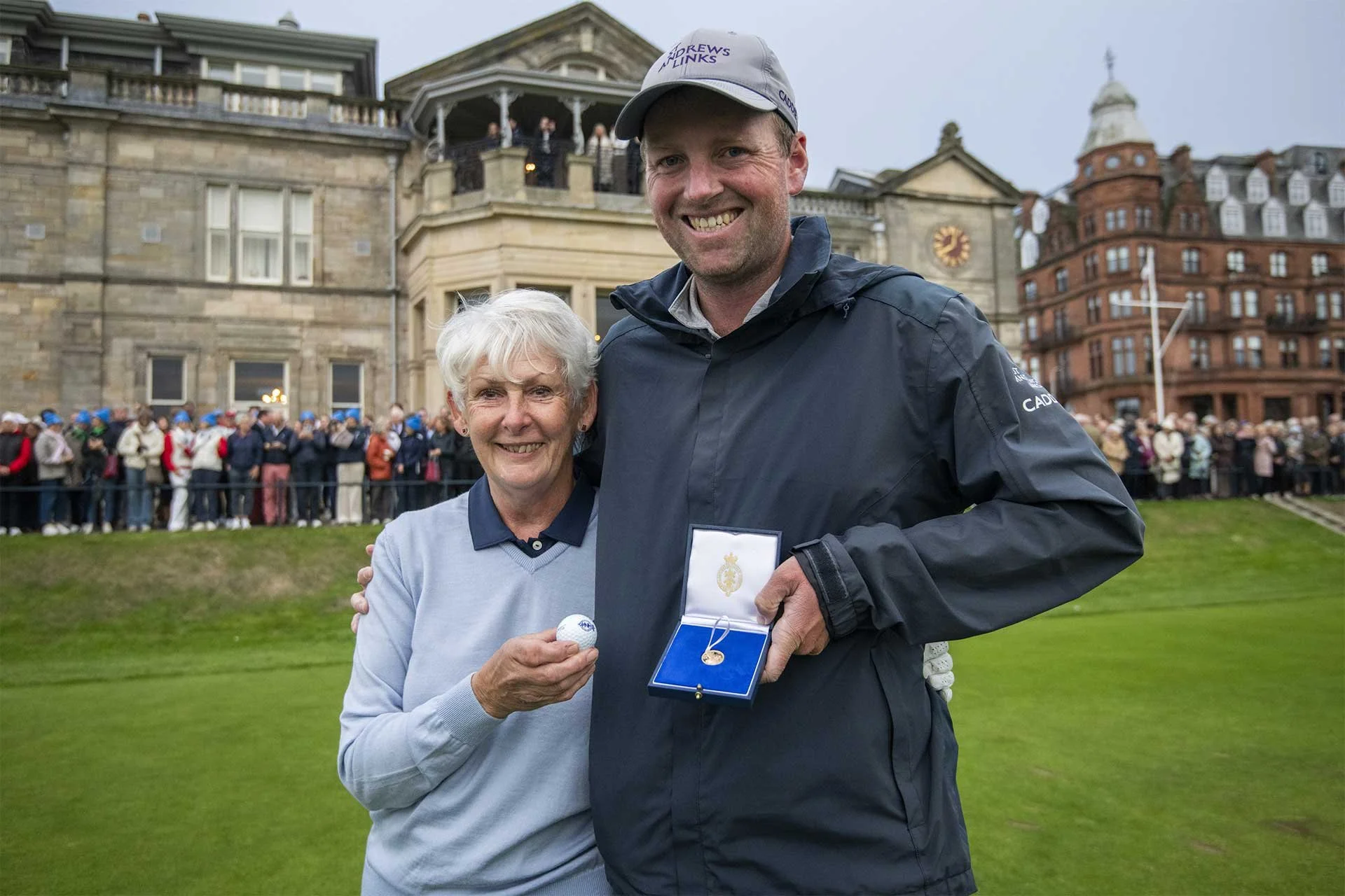 Claire Dowling (left), the new Captain of The Royal and Ancient Golf Club of St Andrews, presents a gold sovereign to caddie Dillon McCarron (right) who successfully returned the ball to Claire. (Photo: R&A)