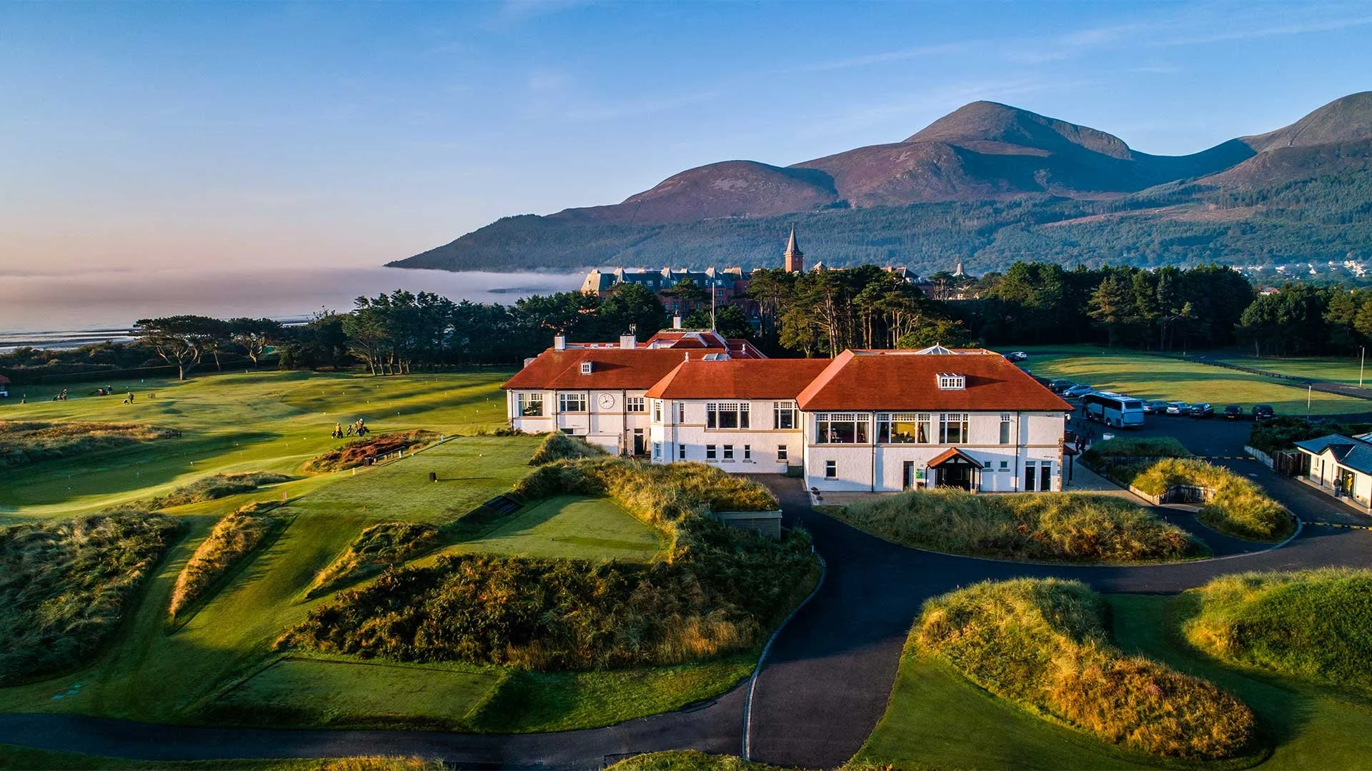 An aerial view of Royal County Down Golf Club in Newcastle with the clubhouse and Mourne Mountains in the background (Photo: Tourism Northern Ireland/Airswing Media)