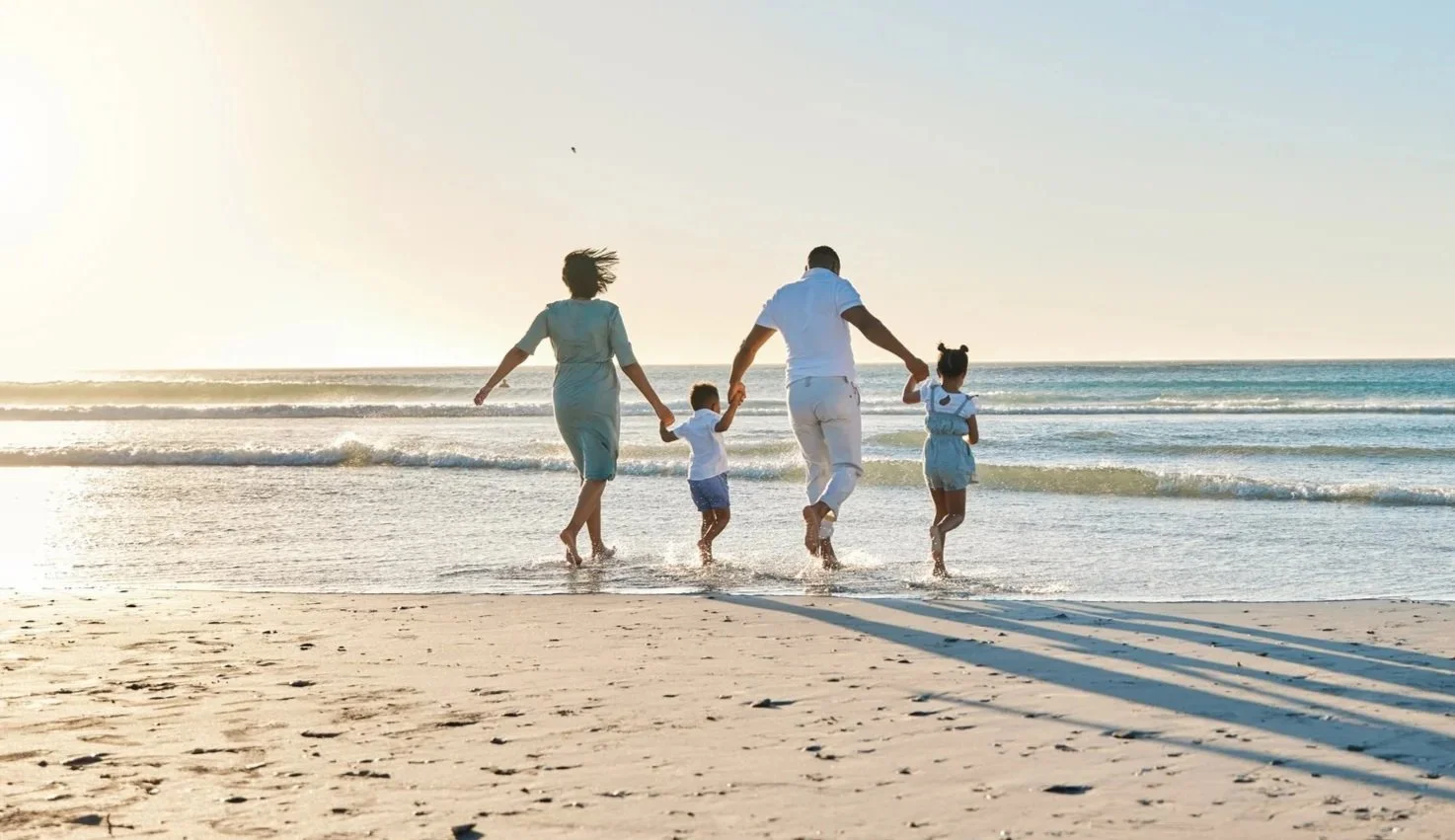 High-net-worth family walking on the beach, symbolizing personalized financial planning and fiduciary wealth management.