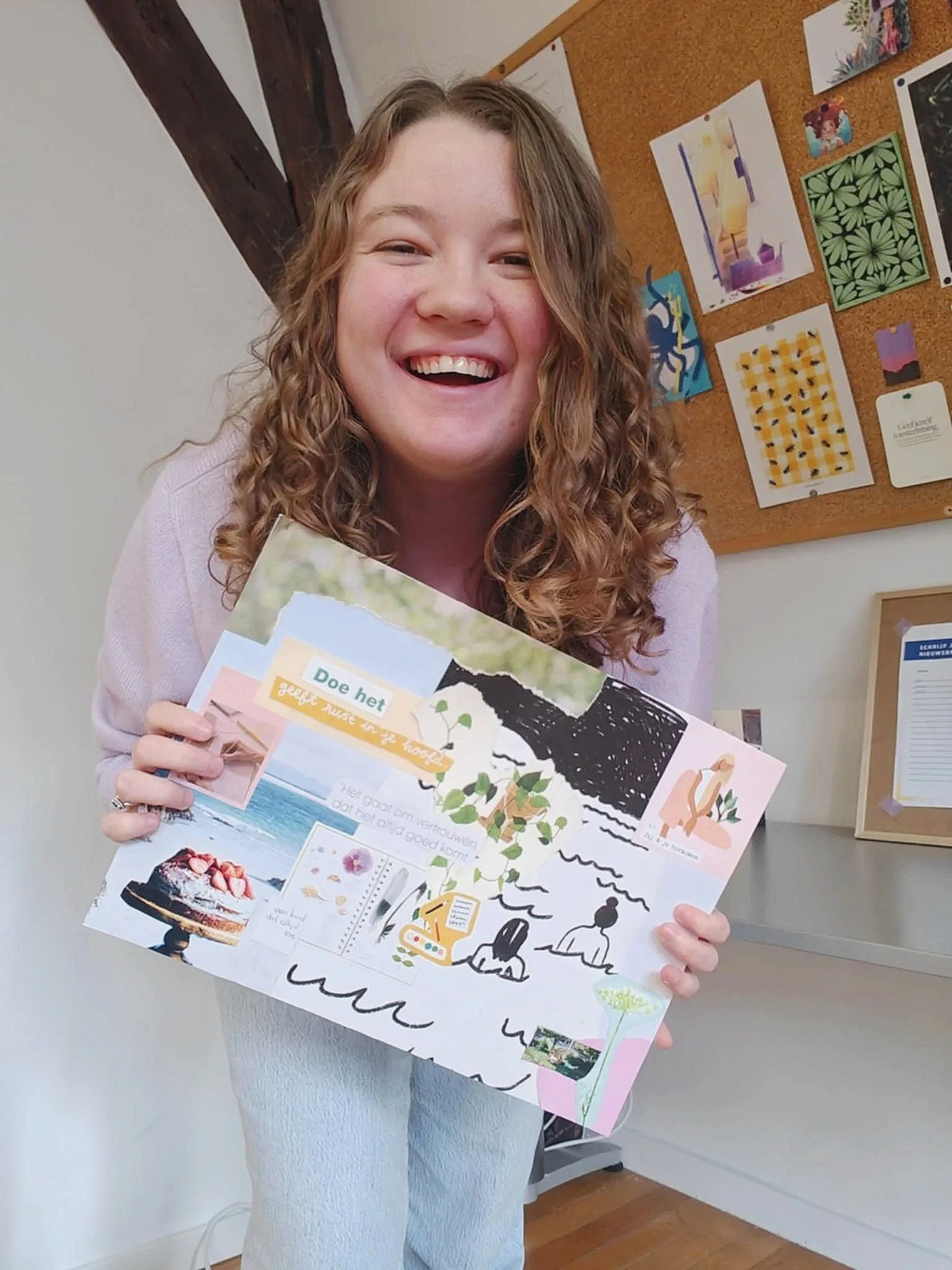 Vrolijke vrouw met lang, golvend haar die een collage vasthoudt.