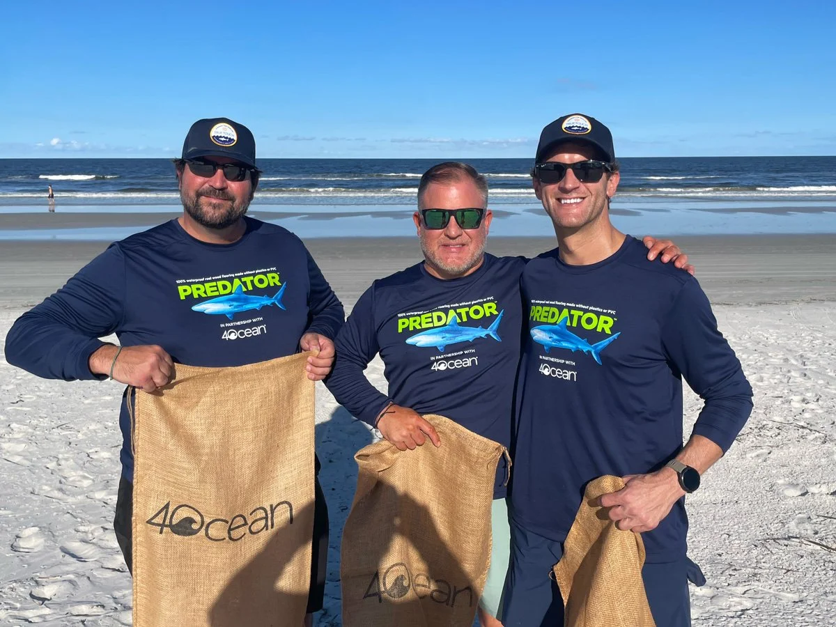 3 men wearing MonopTech Predator shirts holding 4ocean bags cleaning the beach