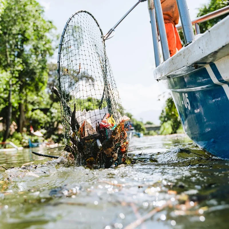 A net pulling plastic and trash from the water
