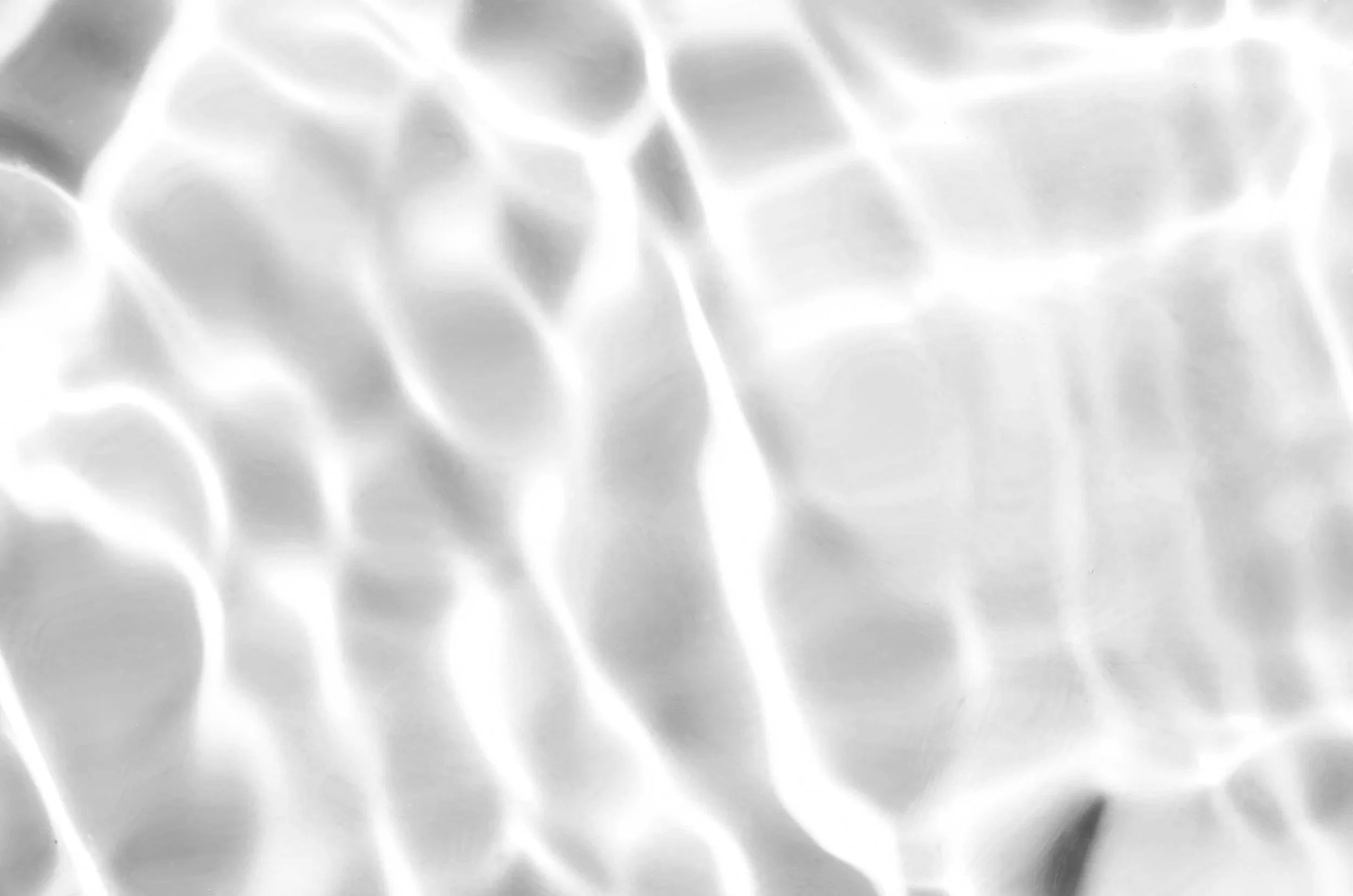 Close-up of rippled, shiny metallic surface with light reflections.