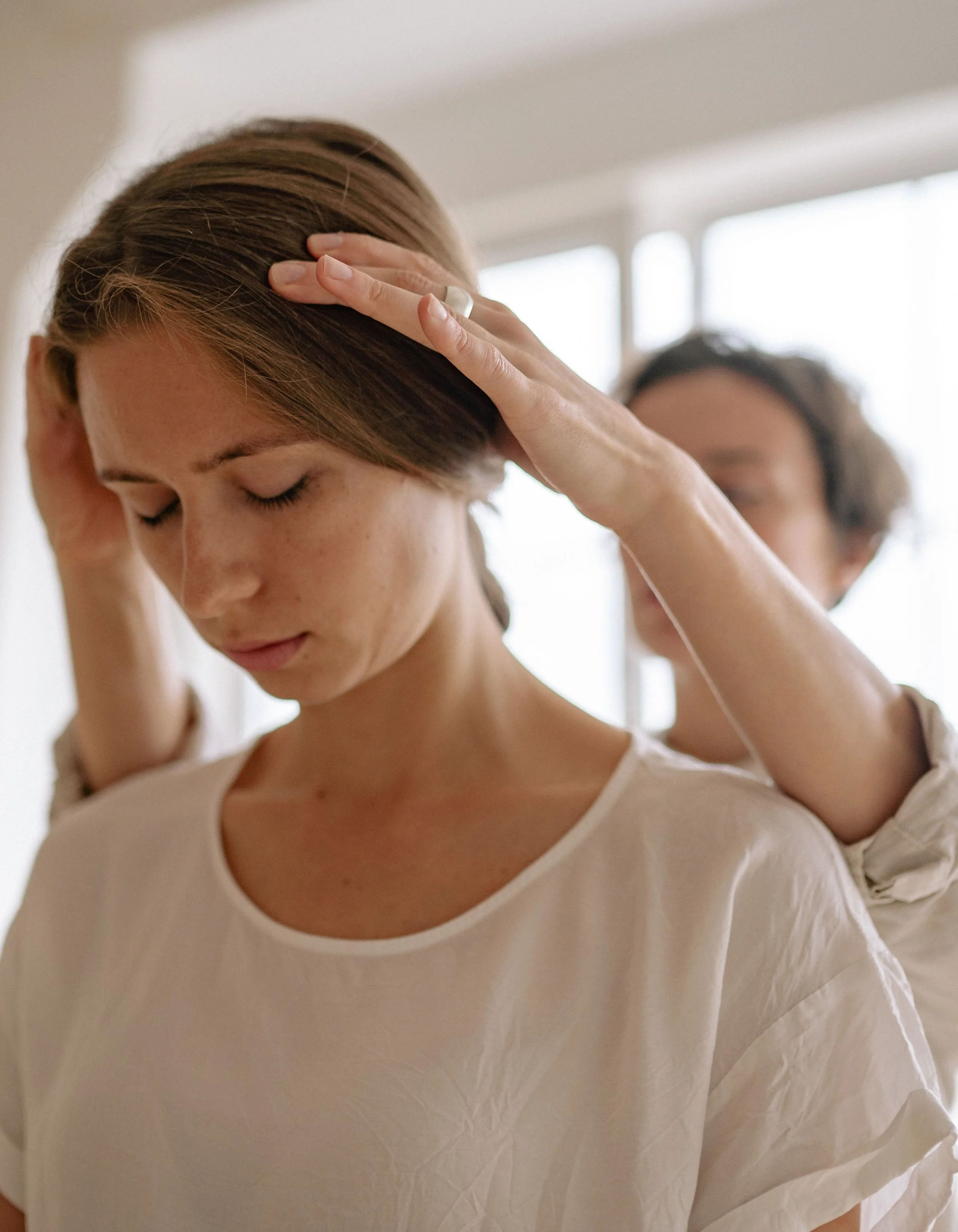 Physiotherapist assessing a patient's head and neck position during vestibular treatment in London, Ontario