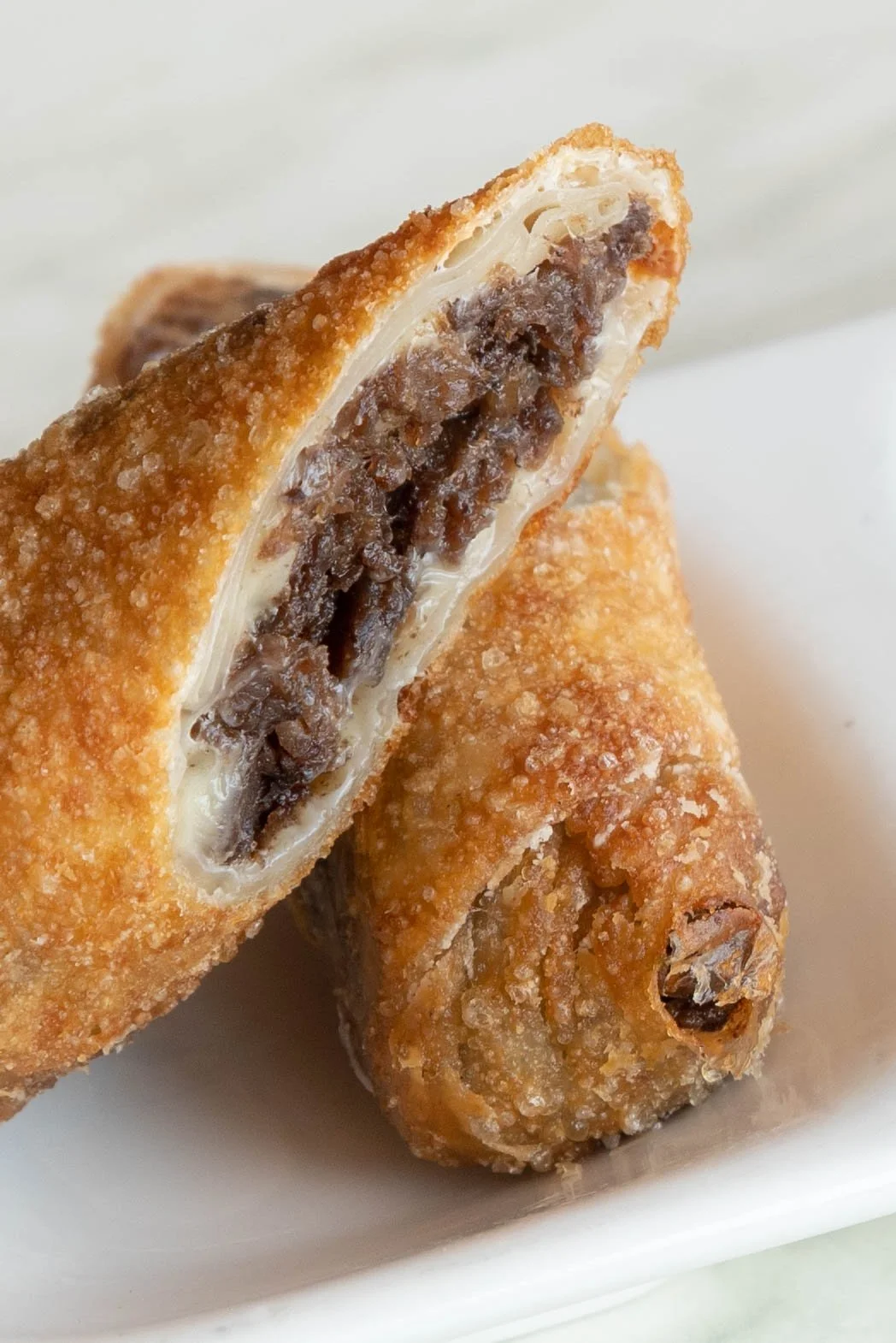 Close-up of a Japanese-style deep-fried dessert with sweet red bean paste filling and a crispy golden exterior.