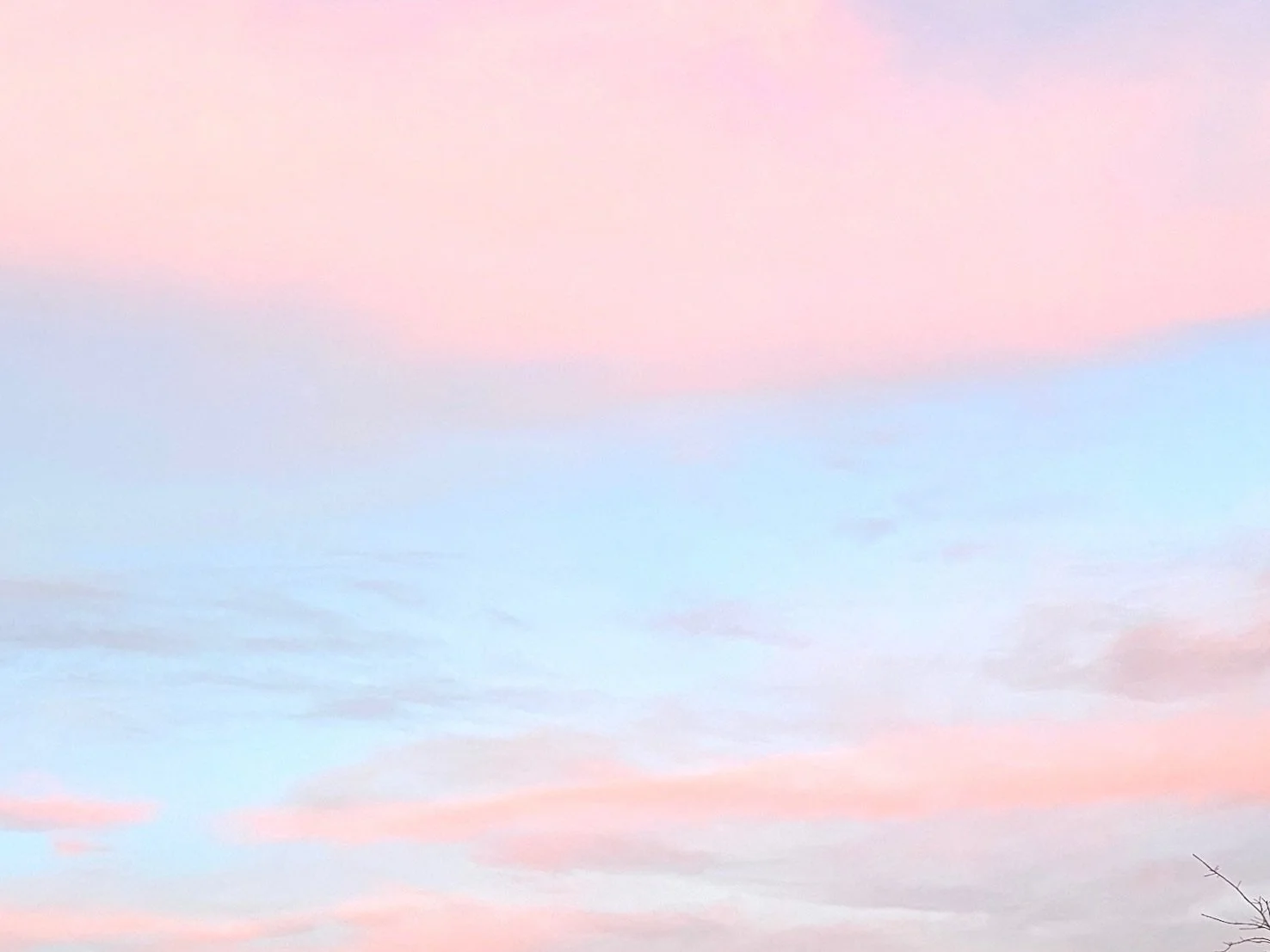 Pink and blue sky with soft clouds at sunrise or sunset.