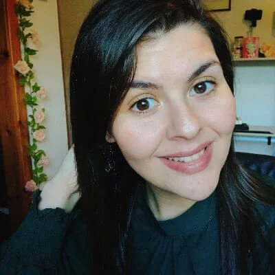 Squarespace designer Chloe Forbes-Kindlen headshot. Straight brown hair, head tilted to left, smiling and wearing a green dress.