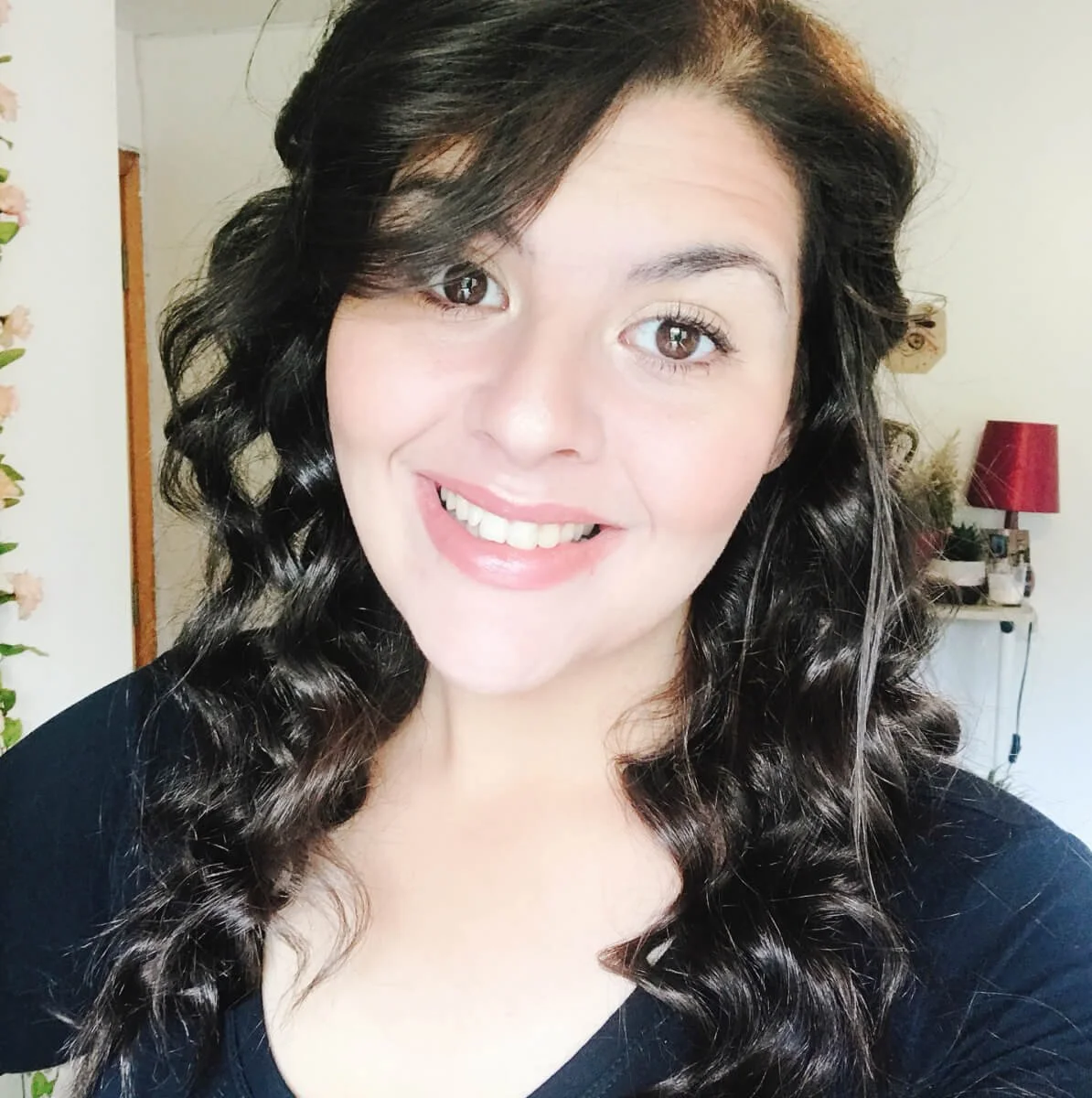 Web Design Coach Chloë Forbes-Kindlen headshot. Smiling with brown curly hair and wearing a black top.
