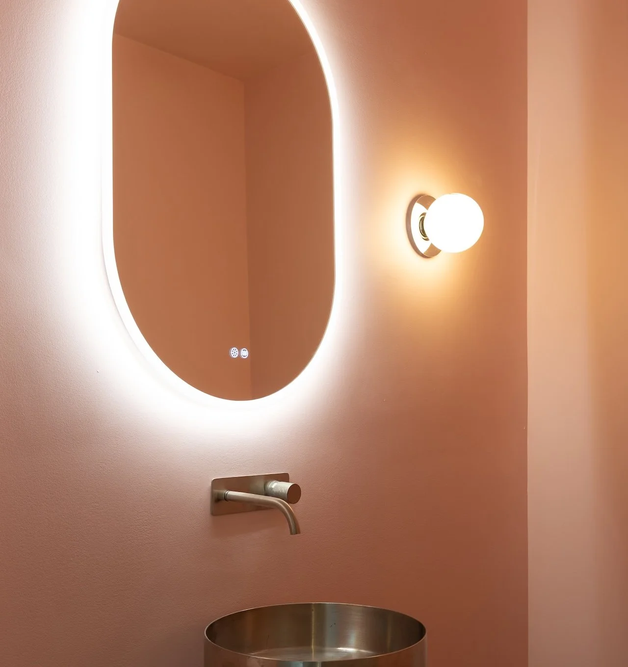 Custom residential bathroom with backlit oval mirror and brushed brass fixtures designed and built by Westrose Construction Toronto