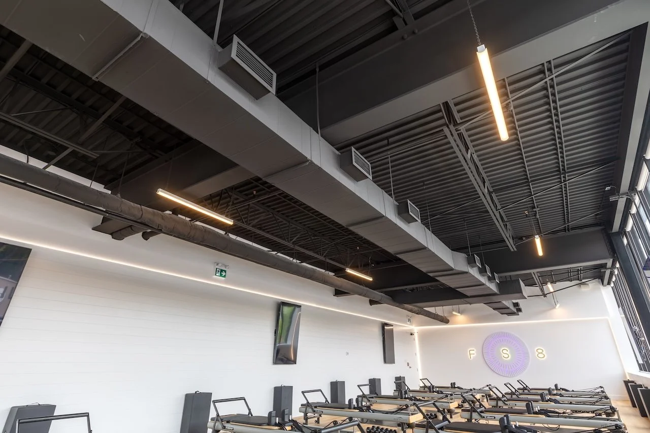 Exposed ceiling and industrial lighting detail at FS8 Port Credit wellness studio by Westrose Construction