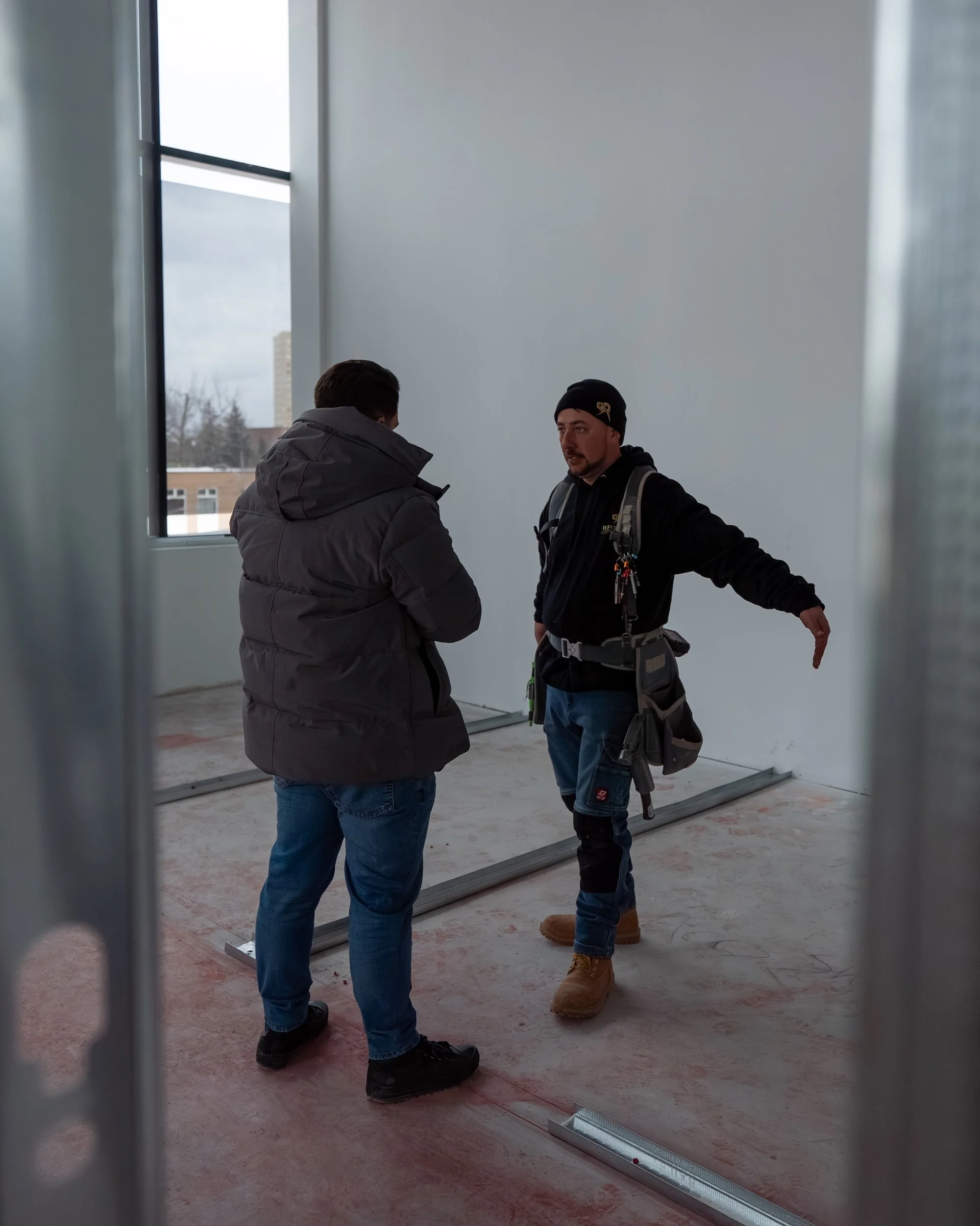 Westrose Construction owner and tradesperson reviewing commercial renovation plans on-site in Toronto during an active build