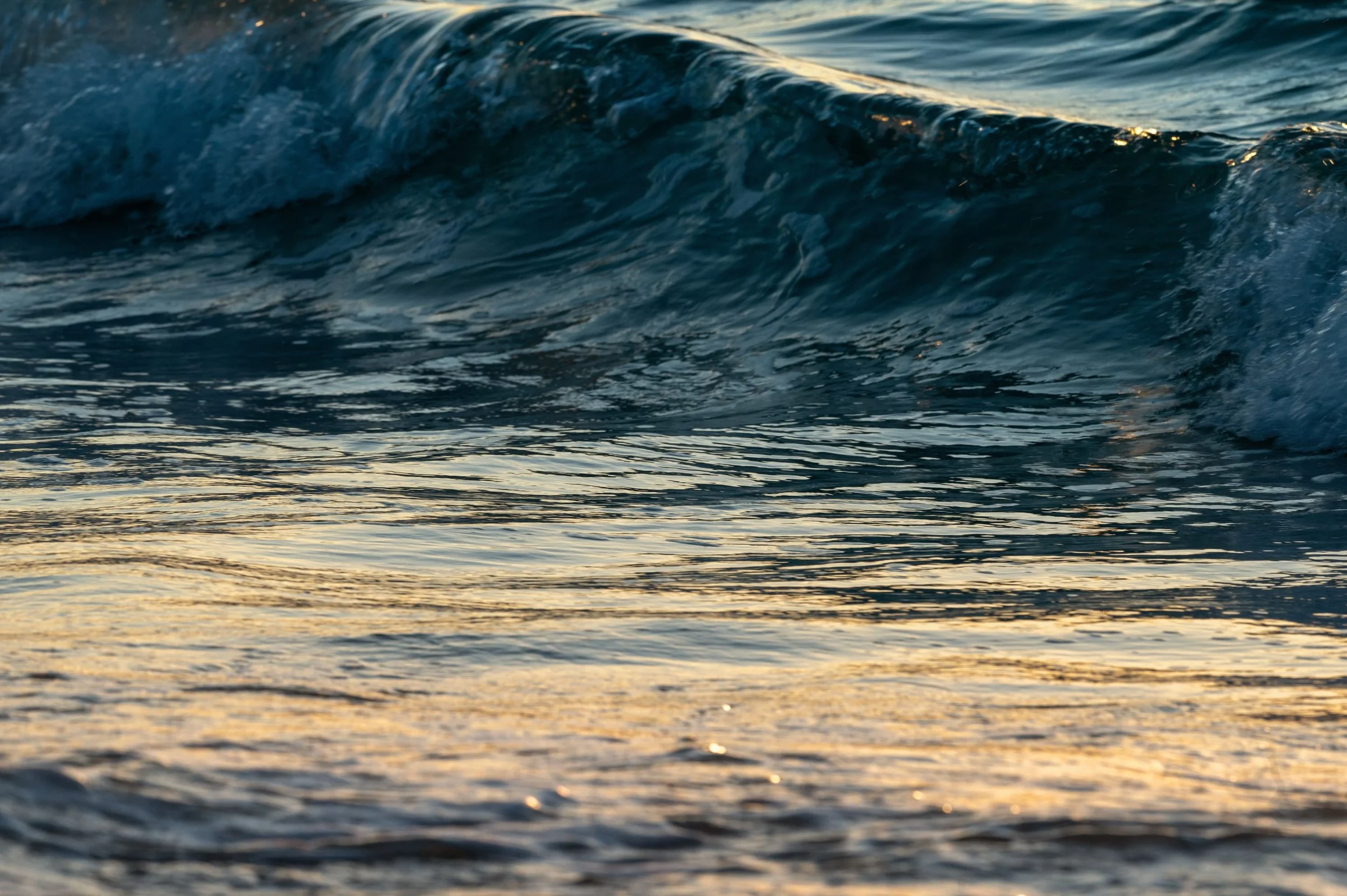Close-up of ocean waves with sunlight reflecting off the water.