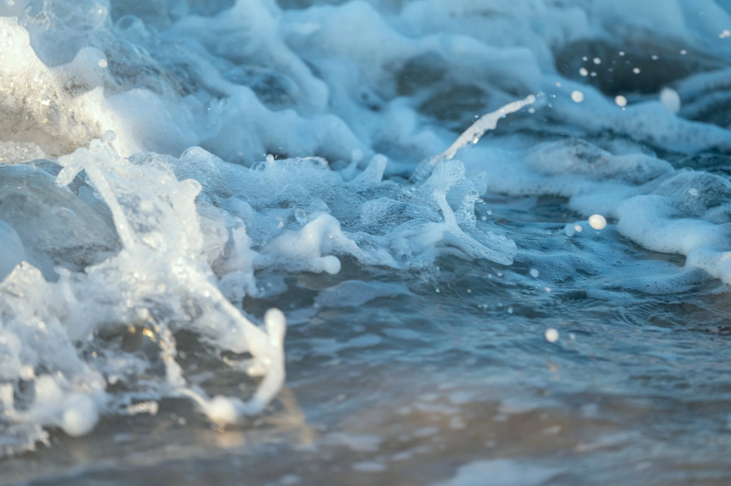 Close-up of ocean waves with white foam on the surface.