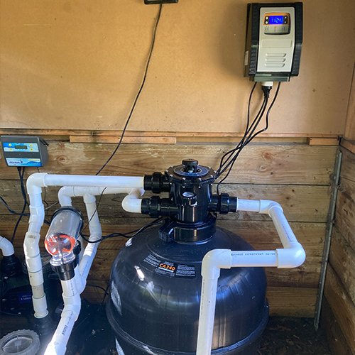 A pool filtration system setup with pipes and control panel.