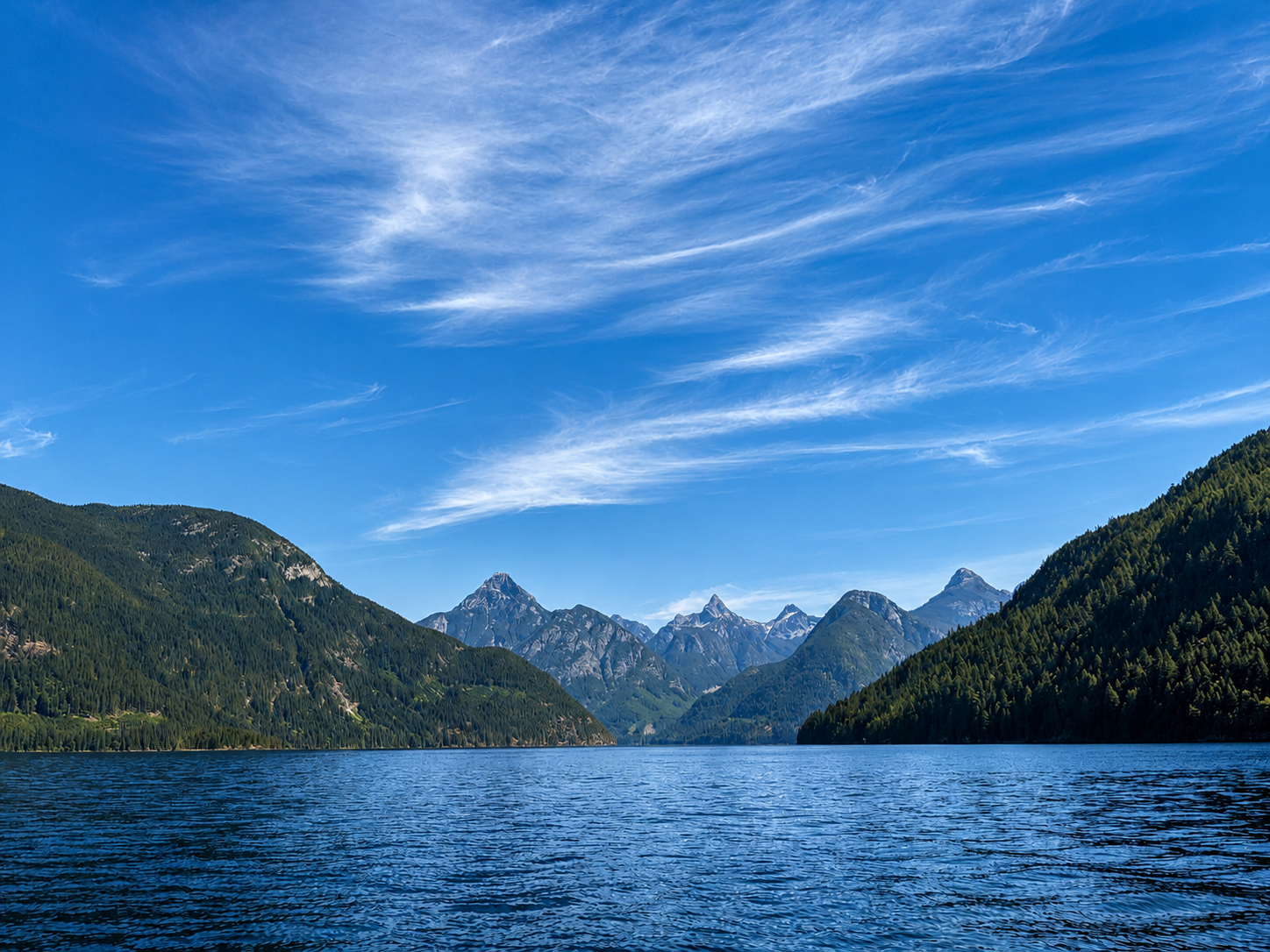 Long view up Powell Lake towards many distant mountains