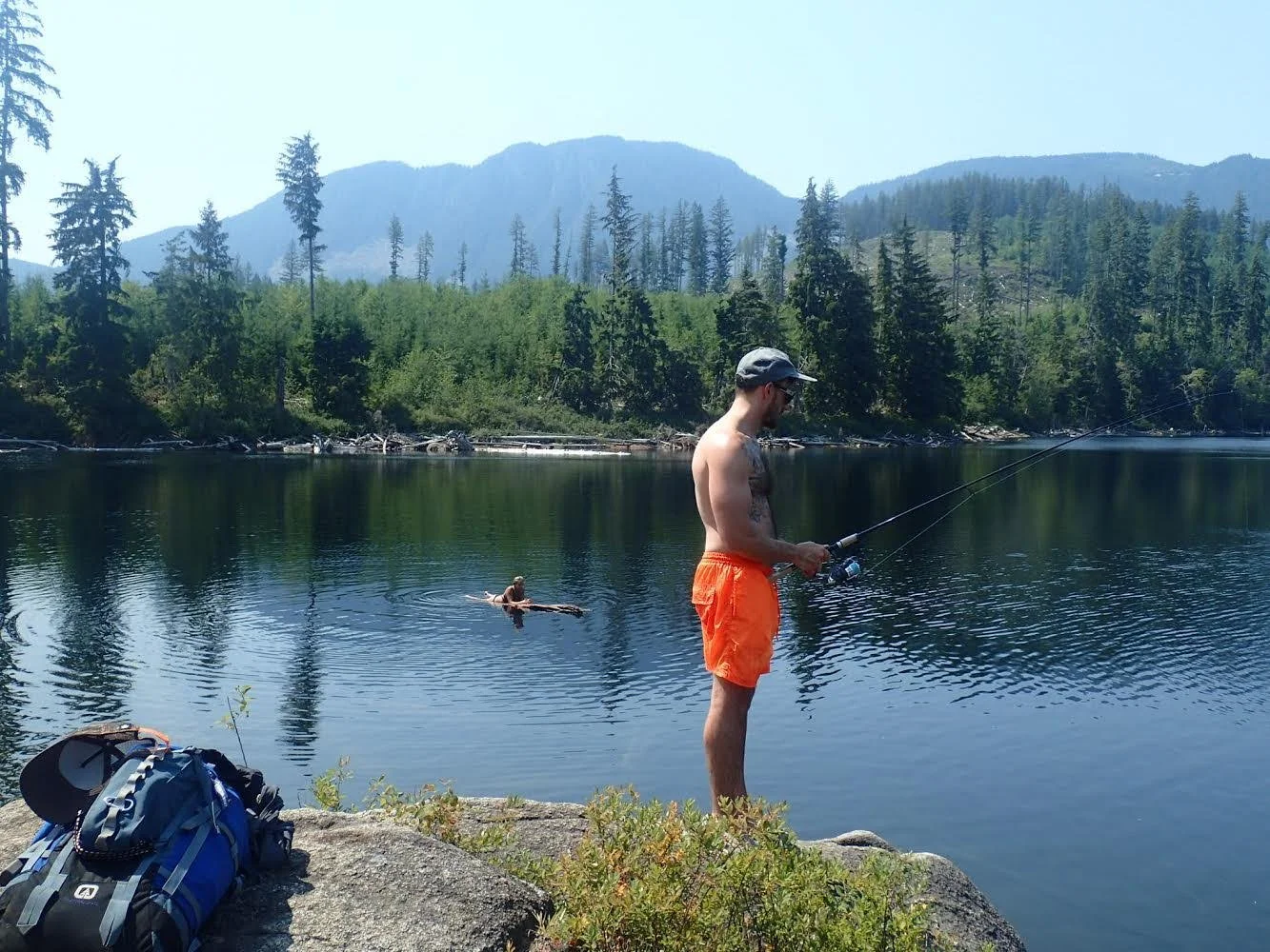 A man fishing from lake shore