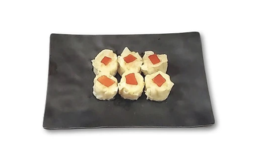 Six pieces of sushi with white wrapping and orange topping on a dark rectangular plate.