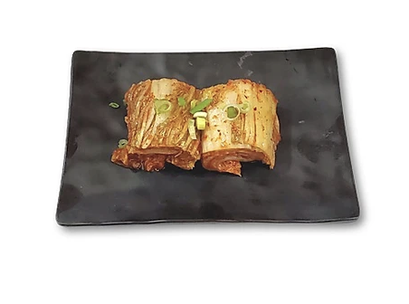 Kimchi served on a black rectangular plate.