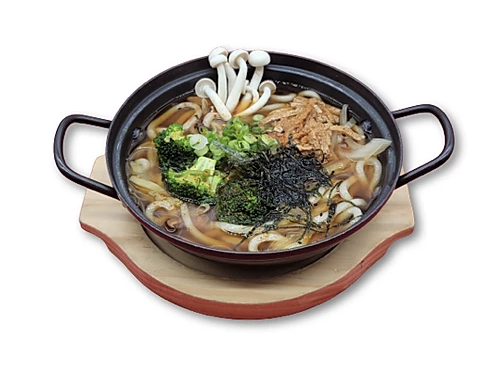 Japanese noodle soup with udon, broccoli, mushrooms, and seaweed in a black bowl on a wooden tray.