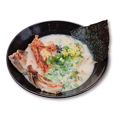 Bowl of ramen with broth, pork slices, green onions, kimchi, seaweed, and vegetables.