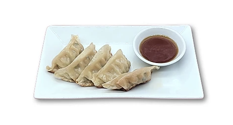 Five dumplings on a rectangular plate with a bowl of dipping sauce.