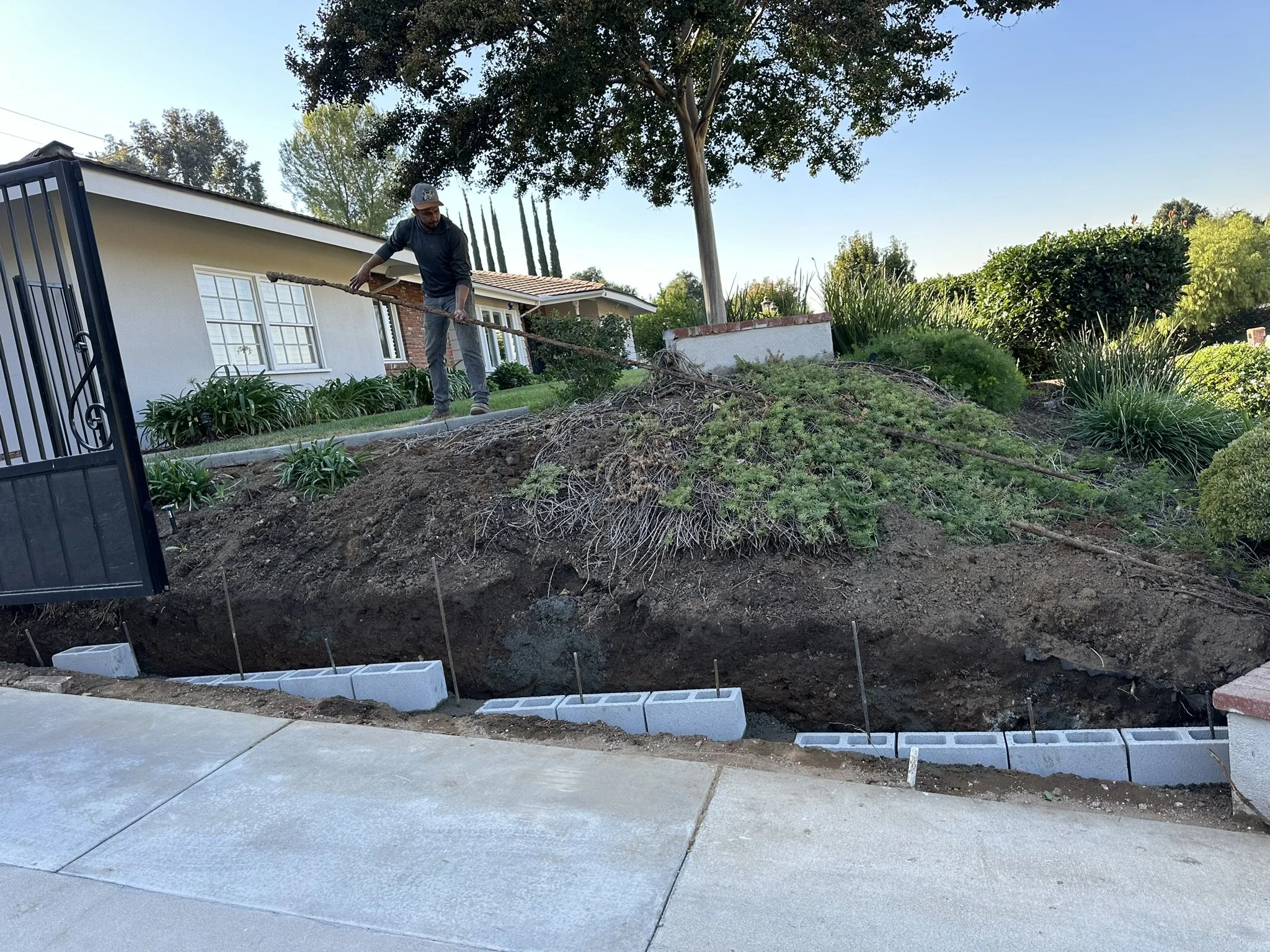 LANDSCAPING & LIGHTING | Before — existing hillside planting area during preparation for landscape improvements.