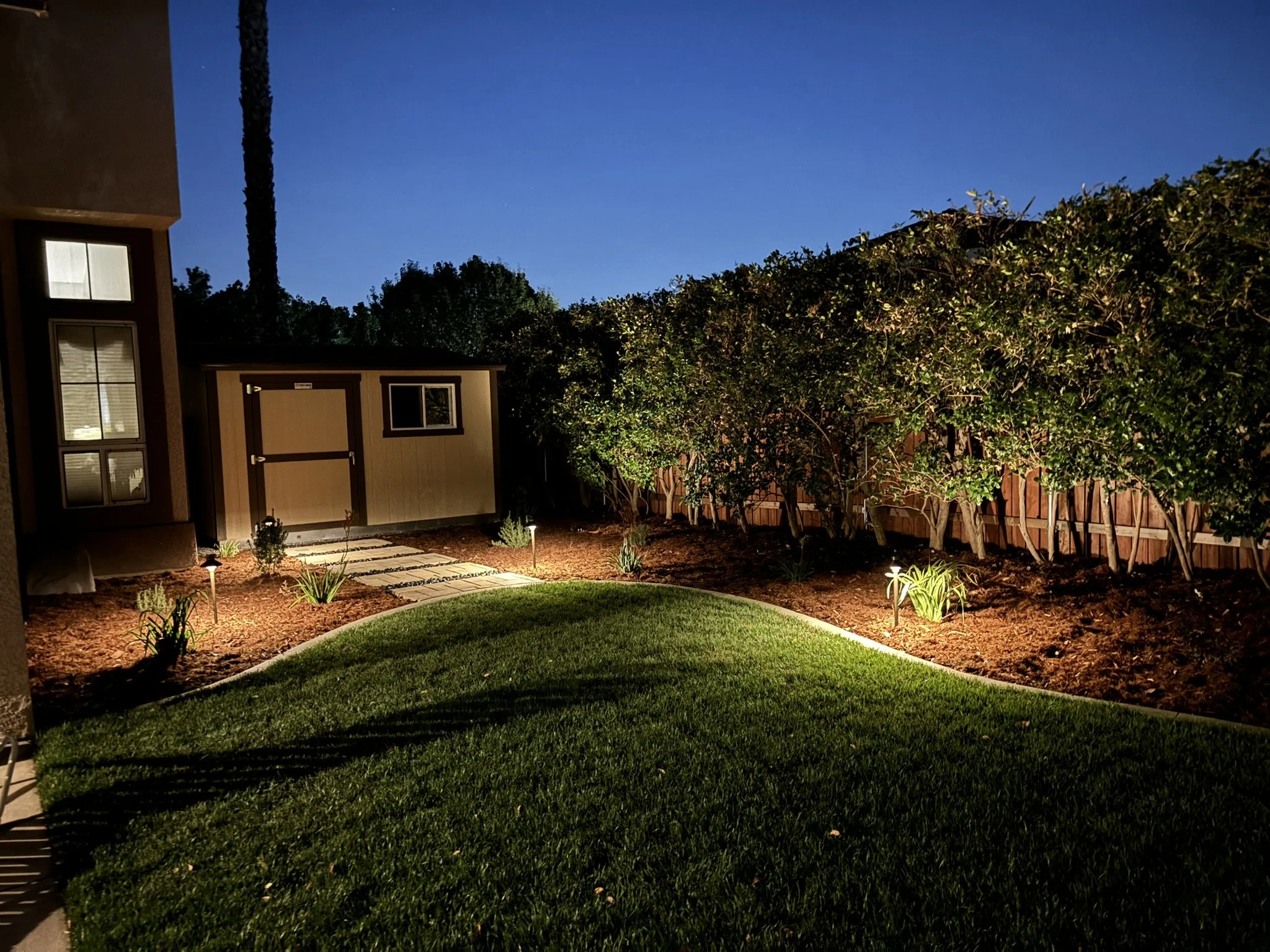 LANDSCAPING & LIGHTING | Evening landscape lighting along the lawn and planting beds.